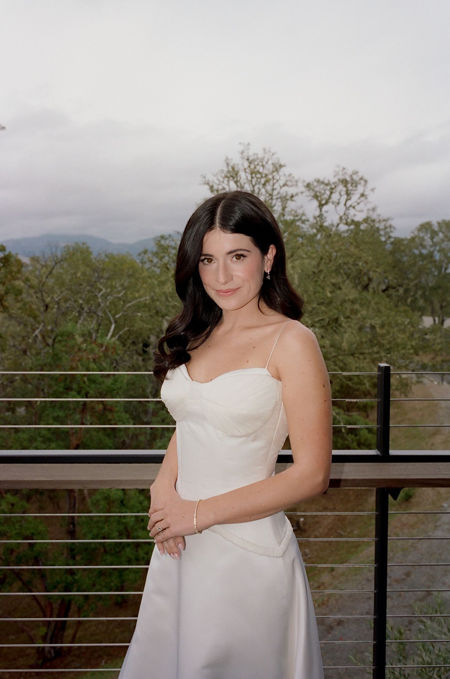 Wedding photography session on an outdoor deck with mountain views in the background.