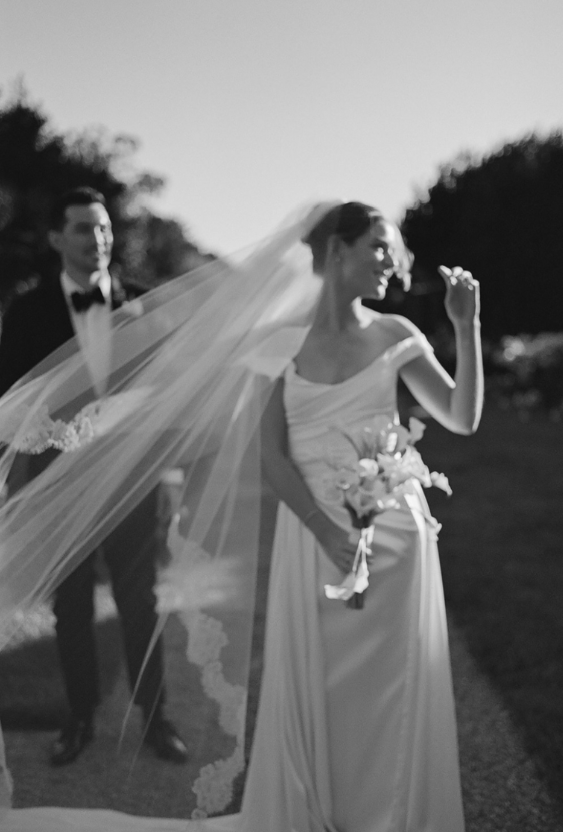 Ethereal black and white photo of flowing wedding dress and veil in motion.