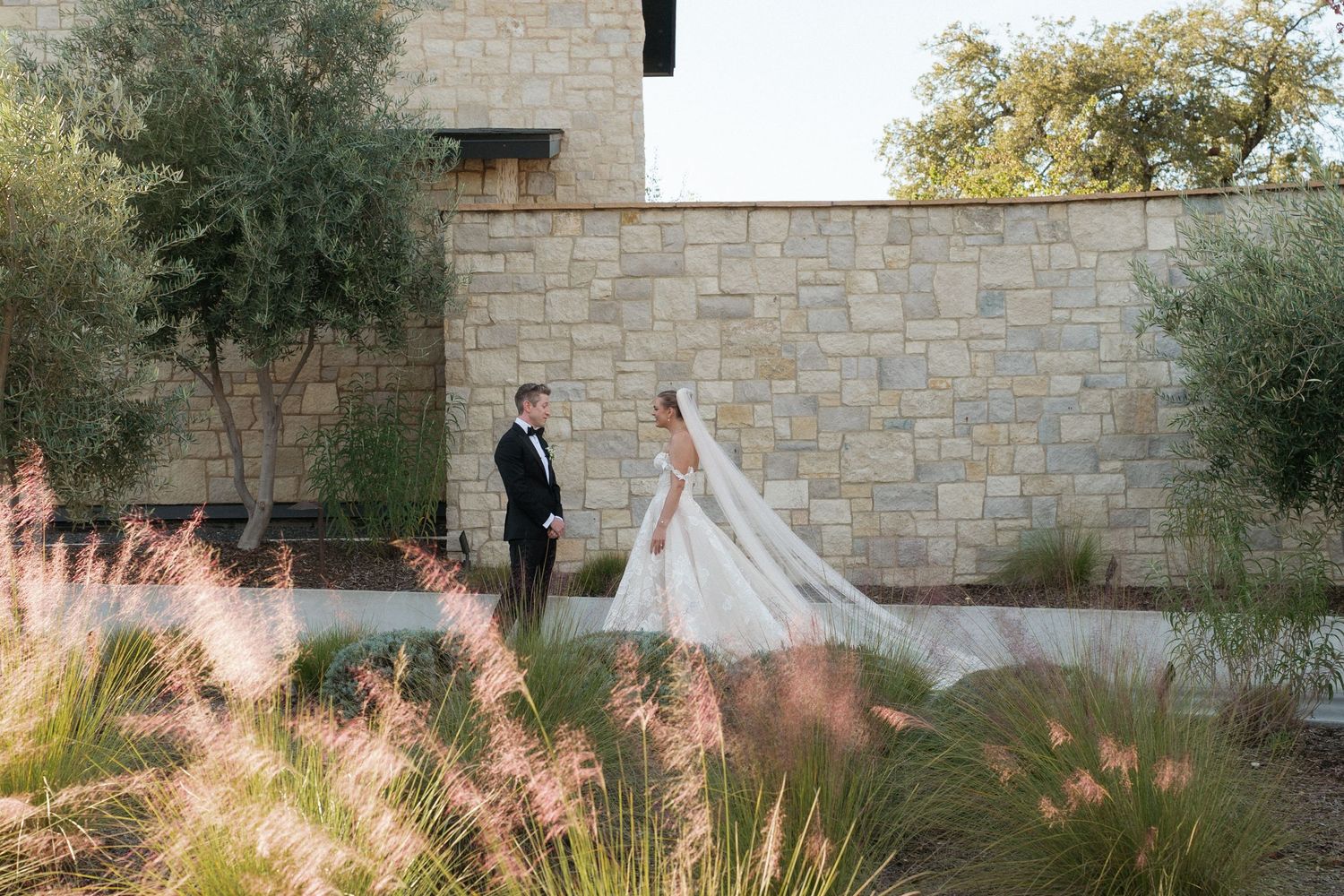Scenic outdoor wedding venue with stone walls and natural landscaping.