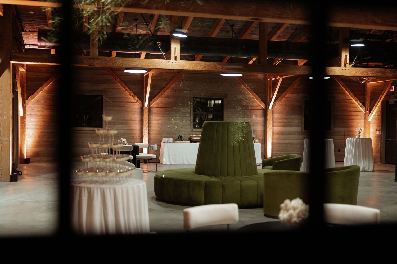 Rustic wooden venue interior with dramatic lighting and wedding reception setup.