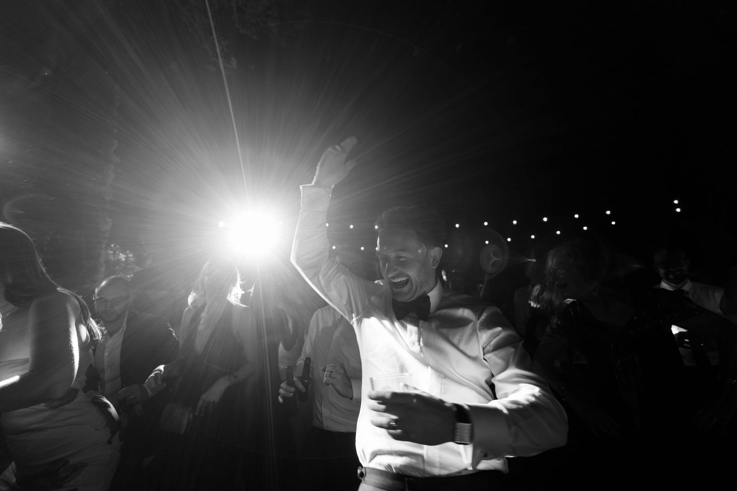 Concert venue with dramatic stage lighting and silhouettes in black and white.