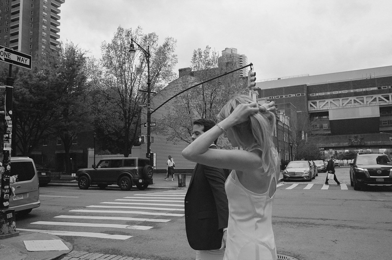 A couple shares a playful moment outdoors near a crosswalk.