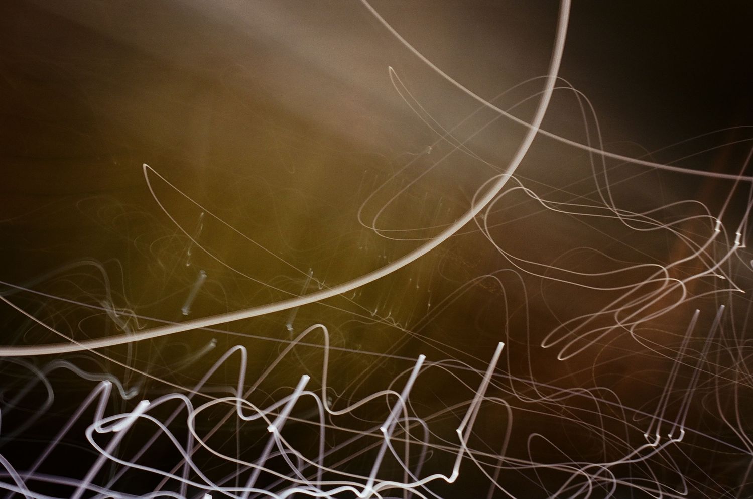 Abstract light trails create flowing patterns against a dark background.