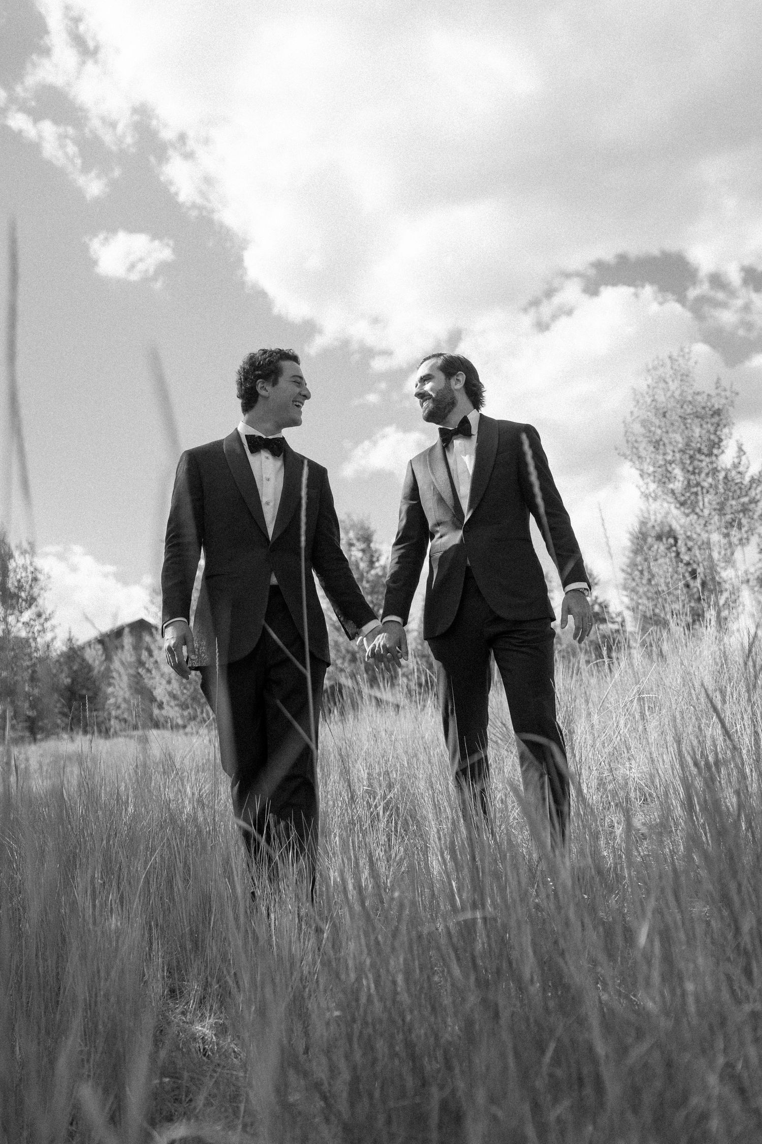 Men in suits walking through tall grass in a candid black and white photo sequence.