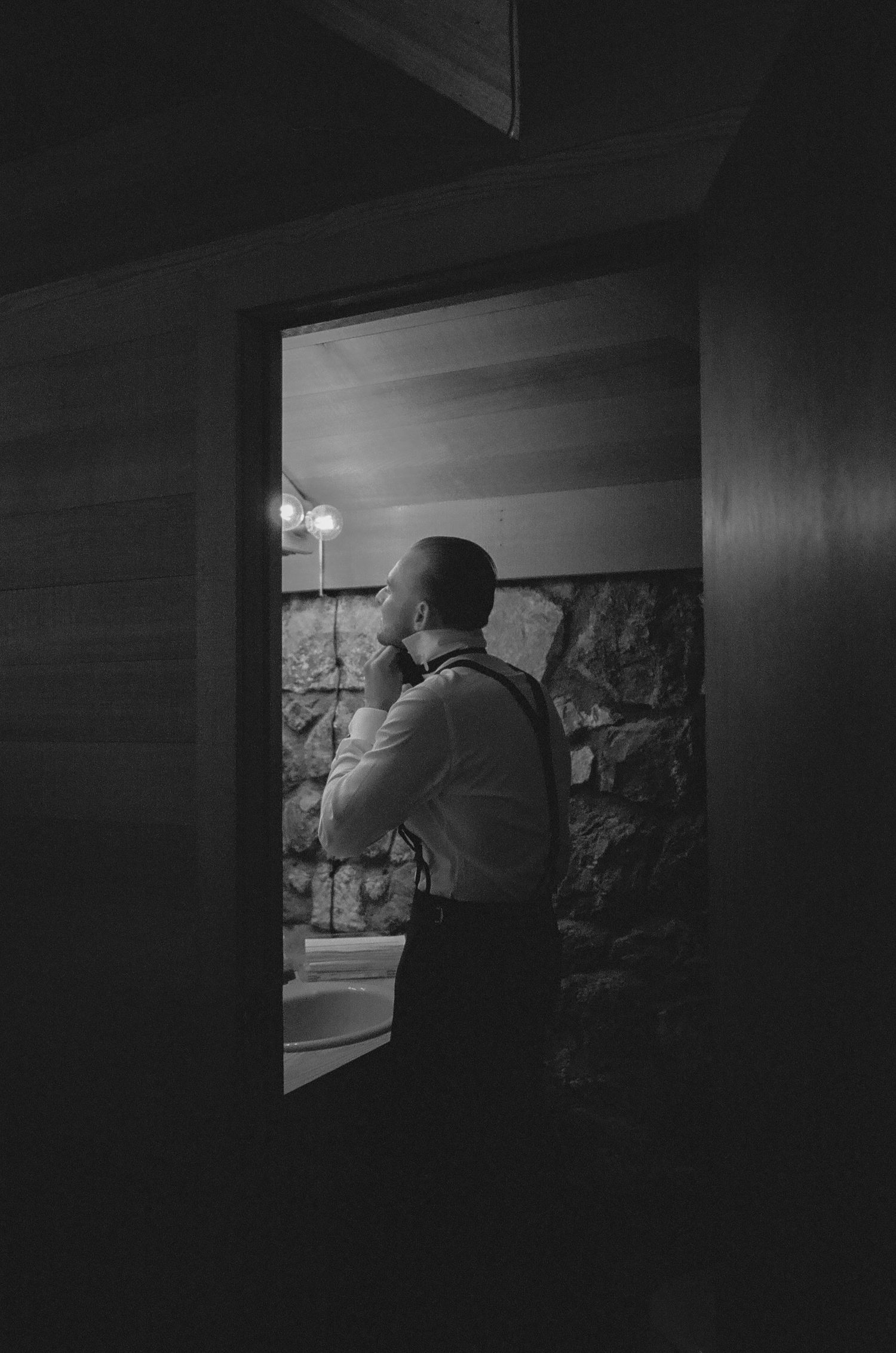 Dramatic black and white photo of a dimly lit interior space with stone walls.