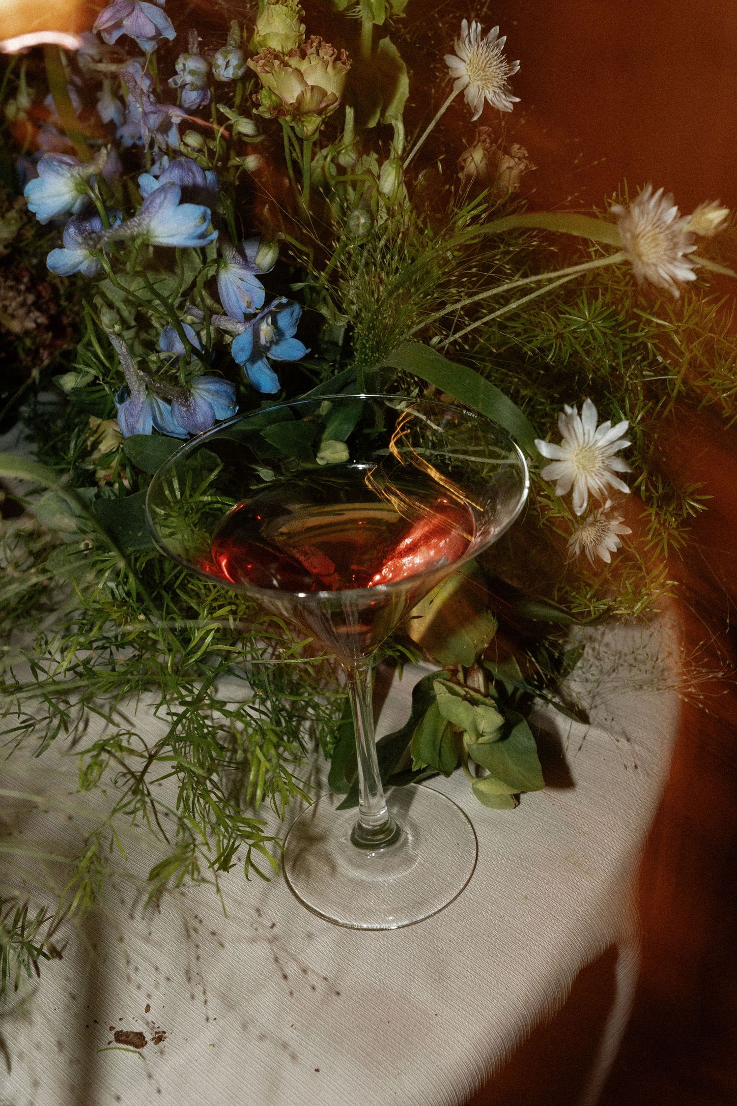Elegant floral centerpieces with white daisies and blue flowers in glass vases.