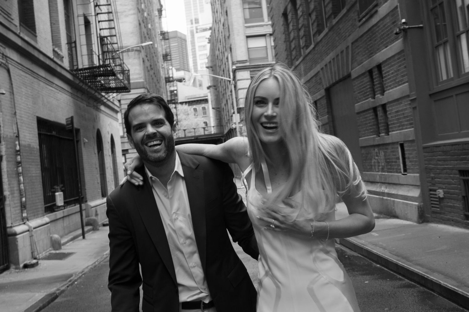 A couple shares a joyful moment together on a city street.