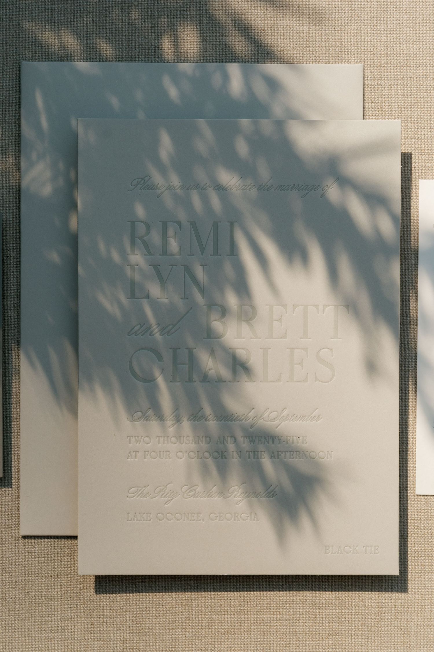 An elegant wedding invitation with shadow overlay in soft blue and white tones.
