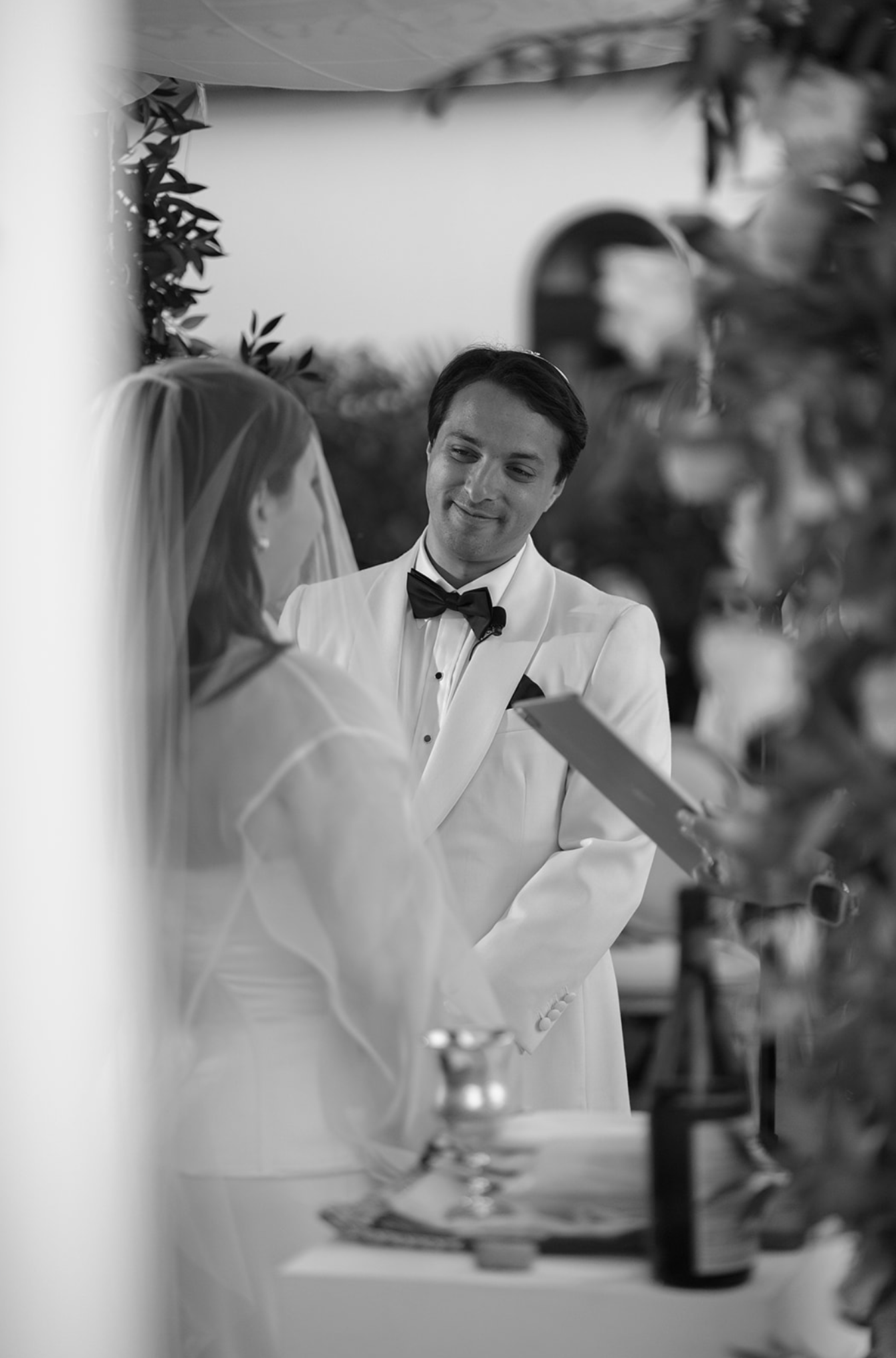 Black and white candid moment between a couple during their wedding celebration.