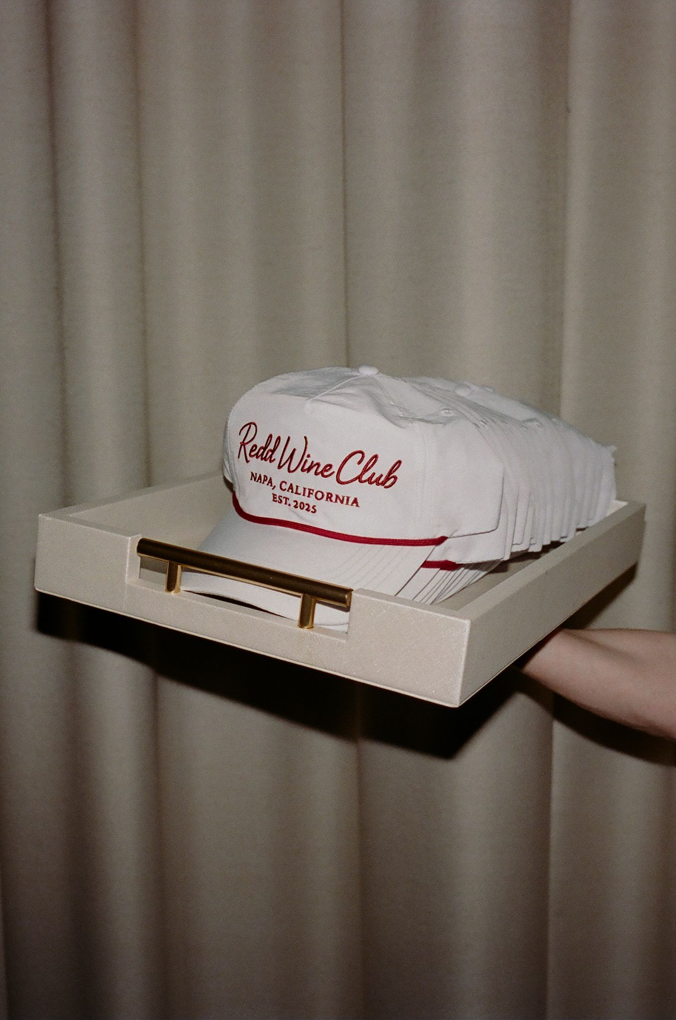 Hands holding a white box with 'Wine Club' text visible against neutral background.