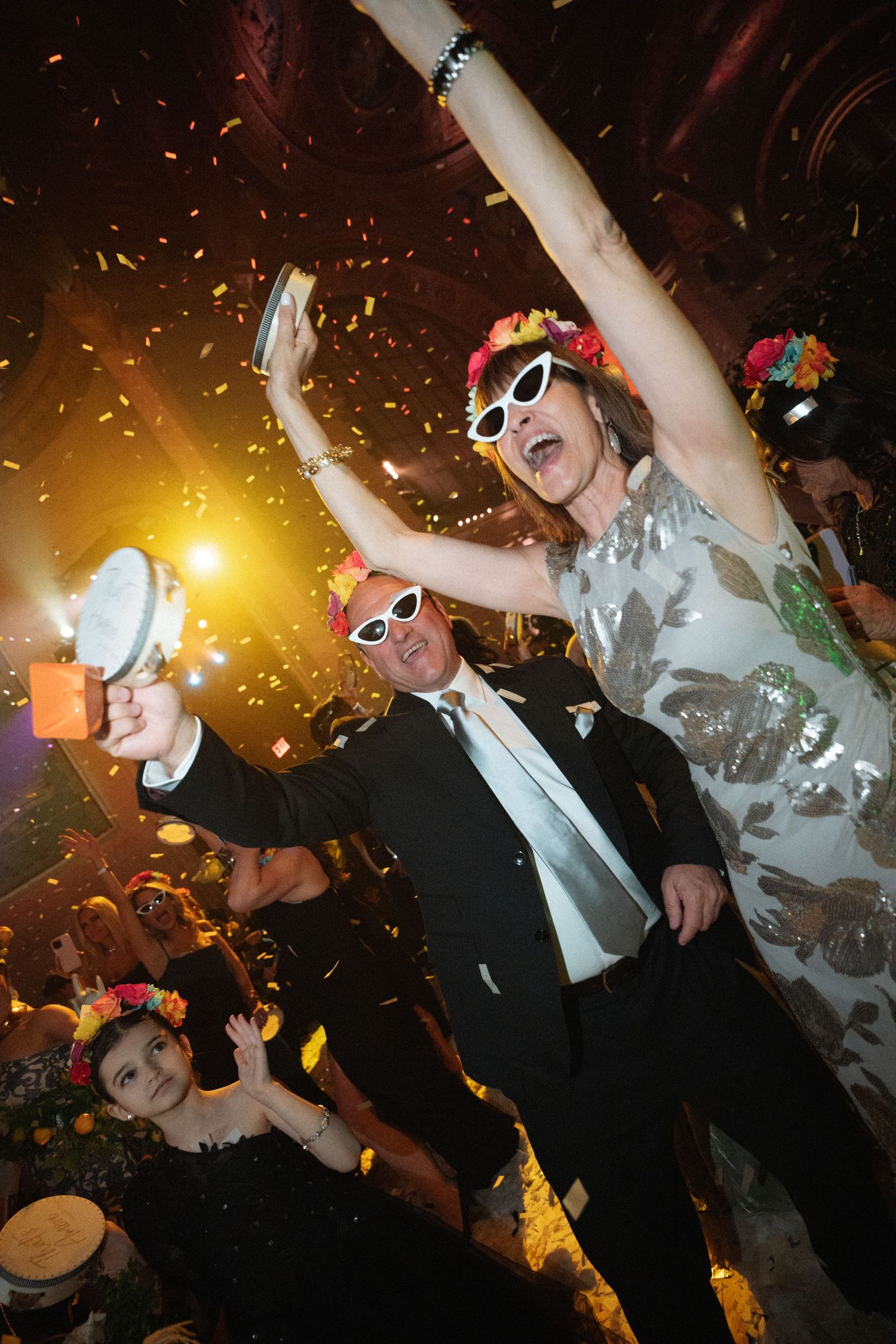 A lively party scene with people dancing and celebrating, with confetti and colorful lighting.
