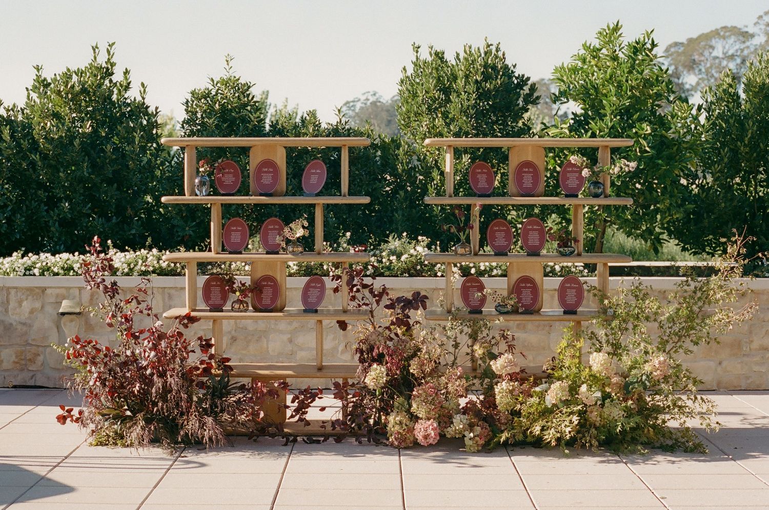 Outdoor wedding venue decorated with potted plants and rustic wooden elements.