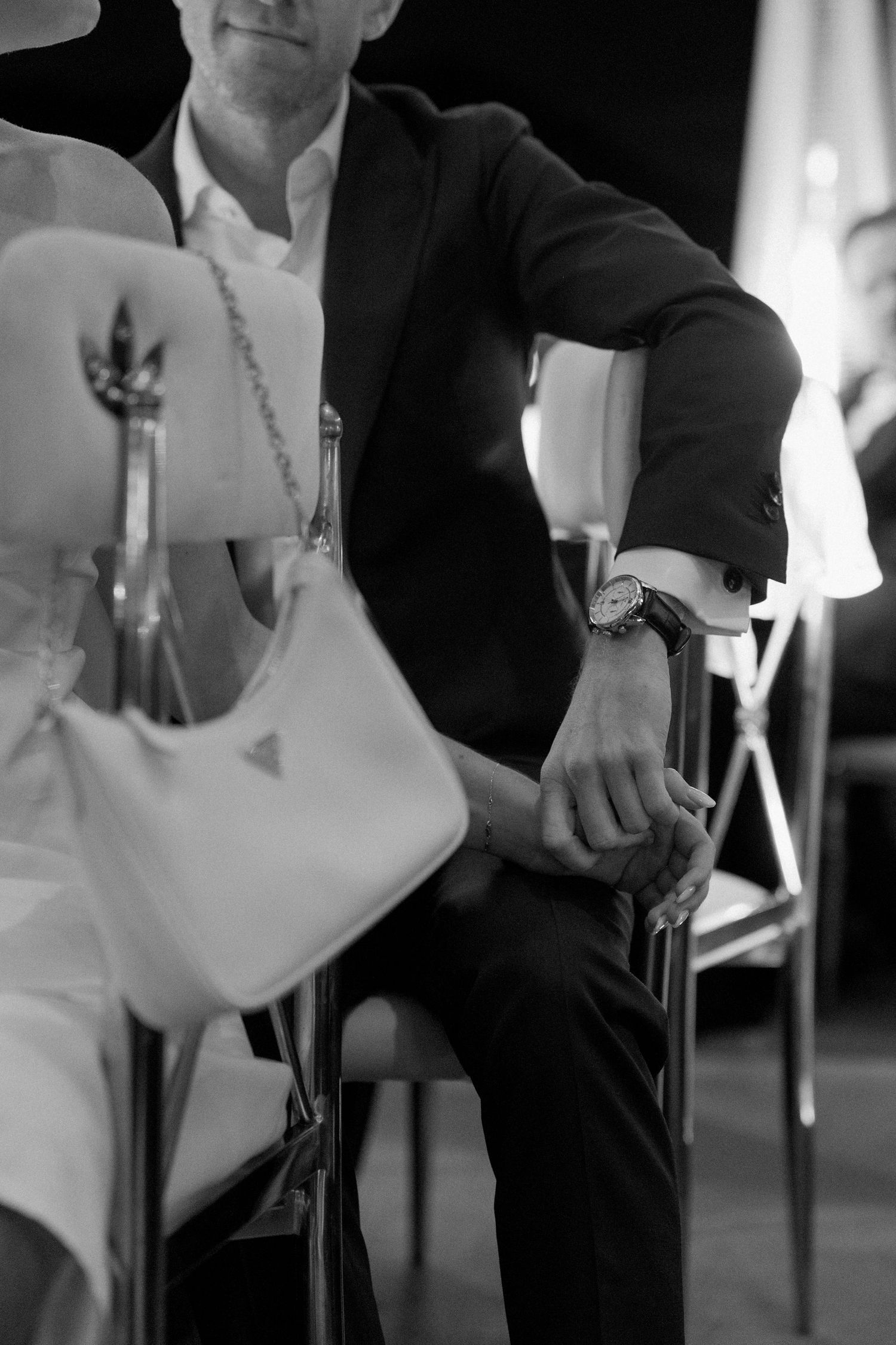 Black and white photograph of formal wedding attire during an intimate moment.