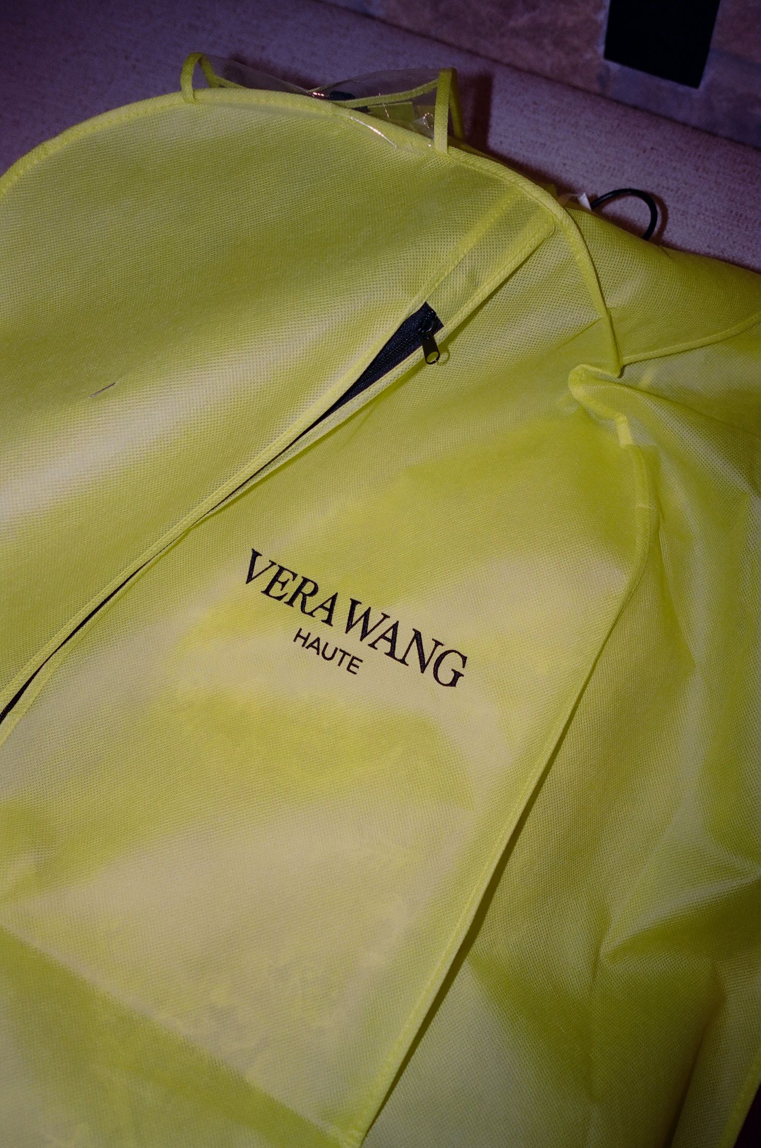 Yellow garment bags with text hang in a row.