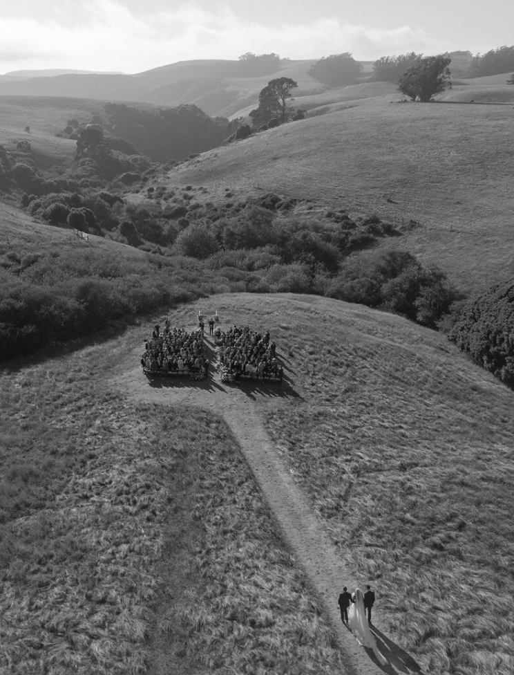 Hiking trail winding through rolling green hills and coastal landscape in black and white.