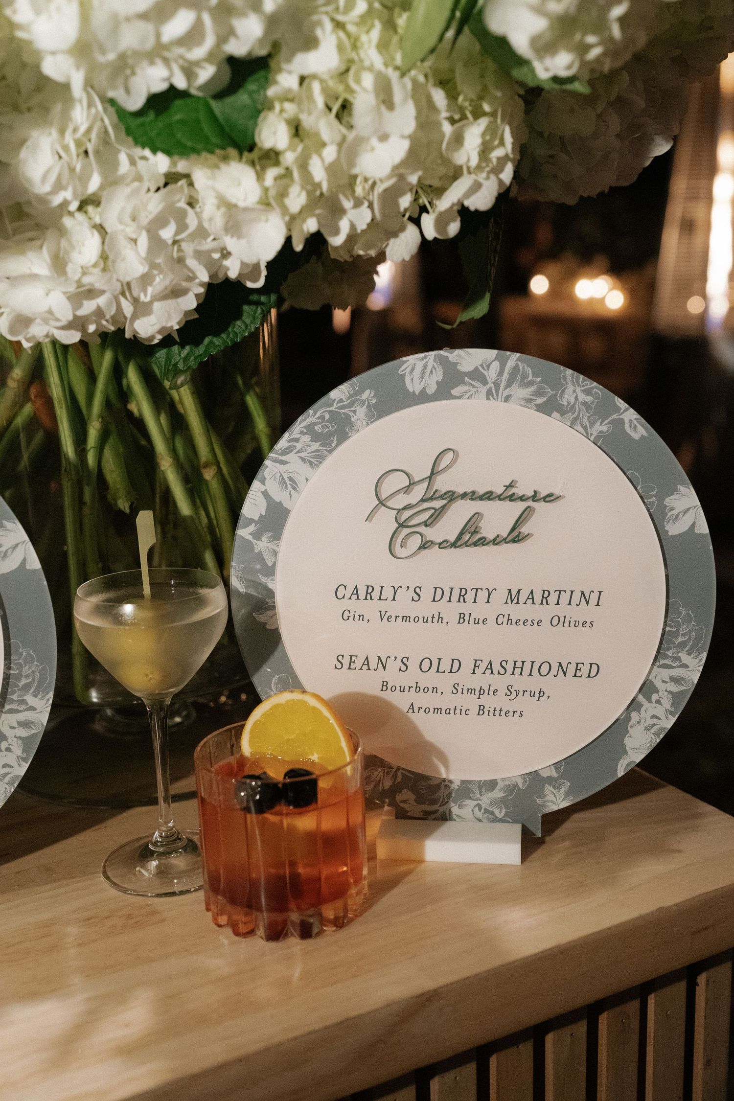 Signature cocktail menu display with martini and old fashioned drinks at an elegant bar setup.