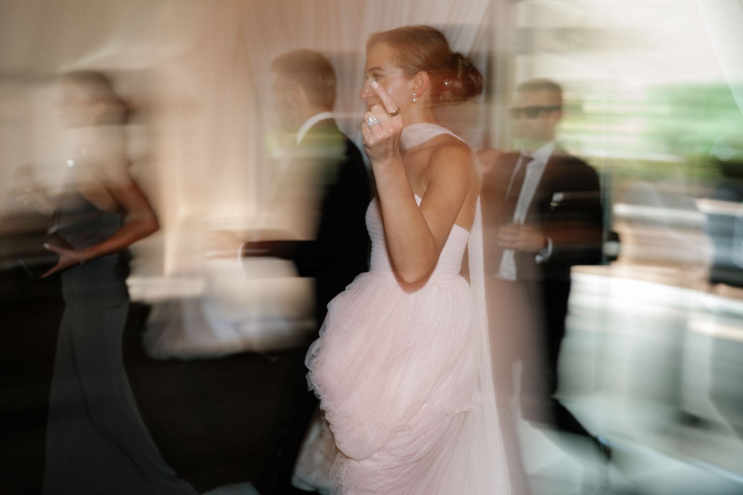 Motion-blurred dancers celebrating at a wedding reception with soft lighting effects.