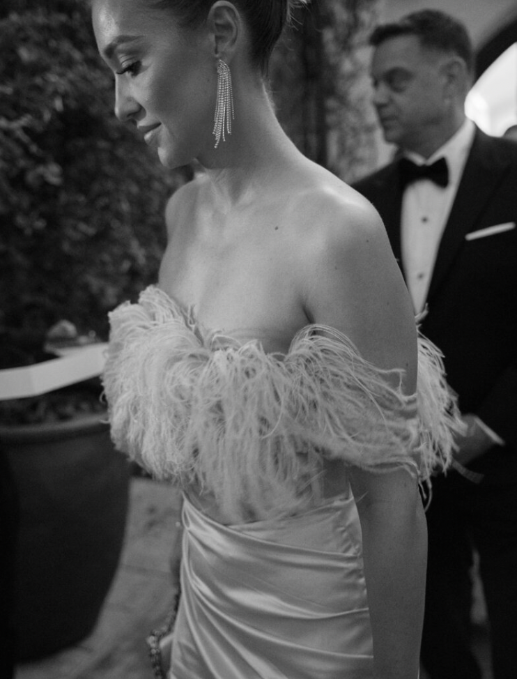 Elegant wedding dress detail showing delicate feather trim and off-shoulder design.