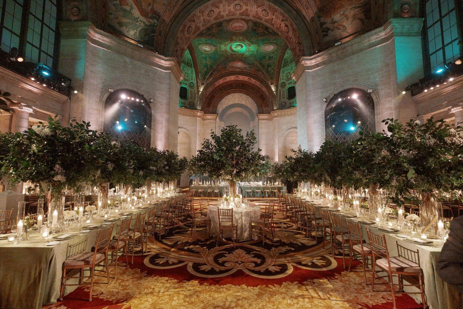 A grand and ornate banquet hall with elaborate decor and floral arrangements.