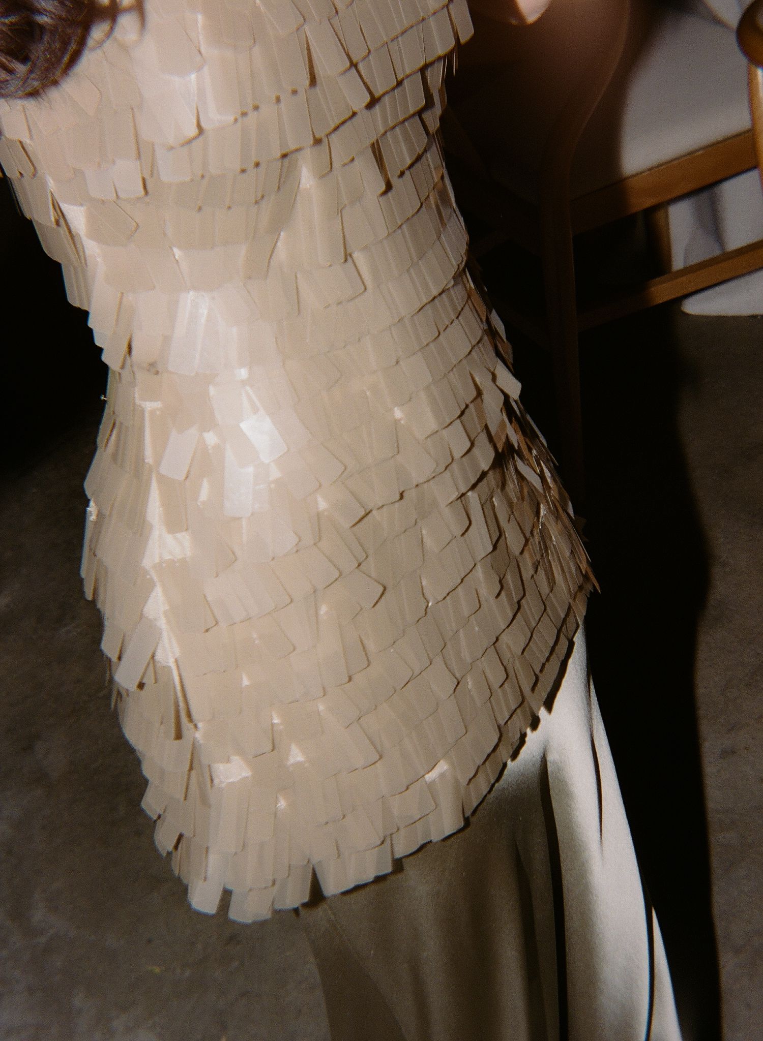 Detail shot of a layered white wedding dress with textured fabric elements.