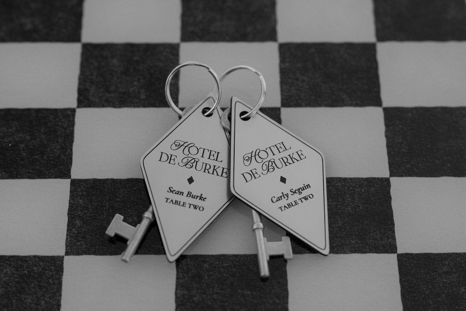 Black and white heart-shaped wedding place cards arranged in a pattern.