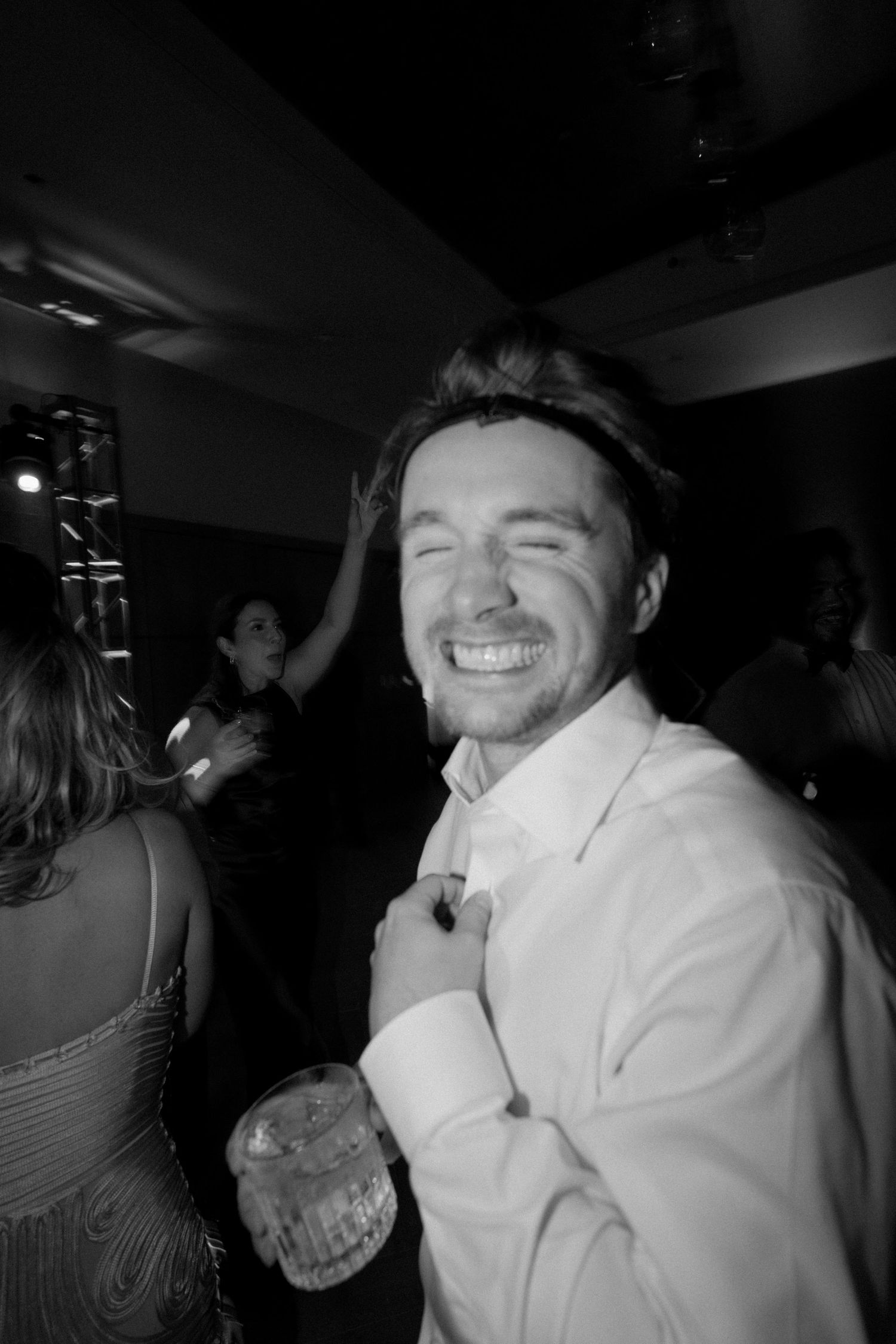 Person in white clothing dancing and celebrating at a party.