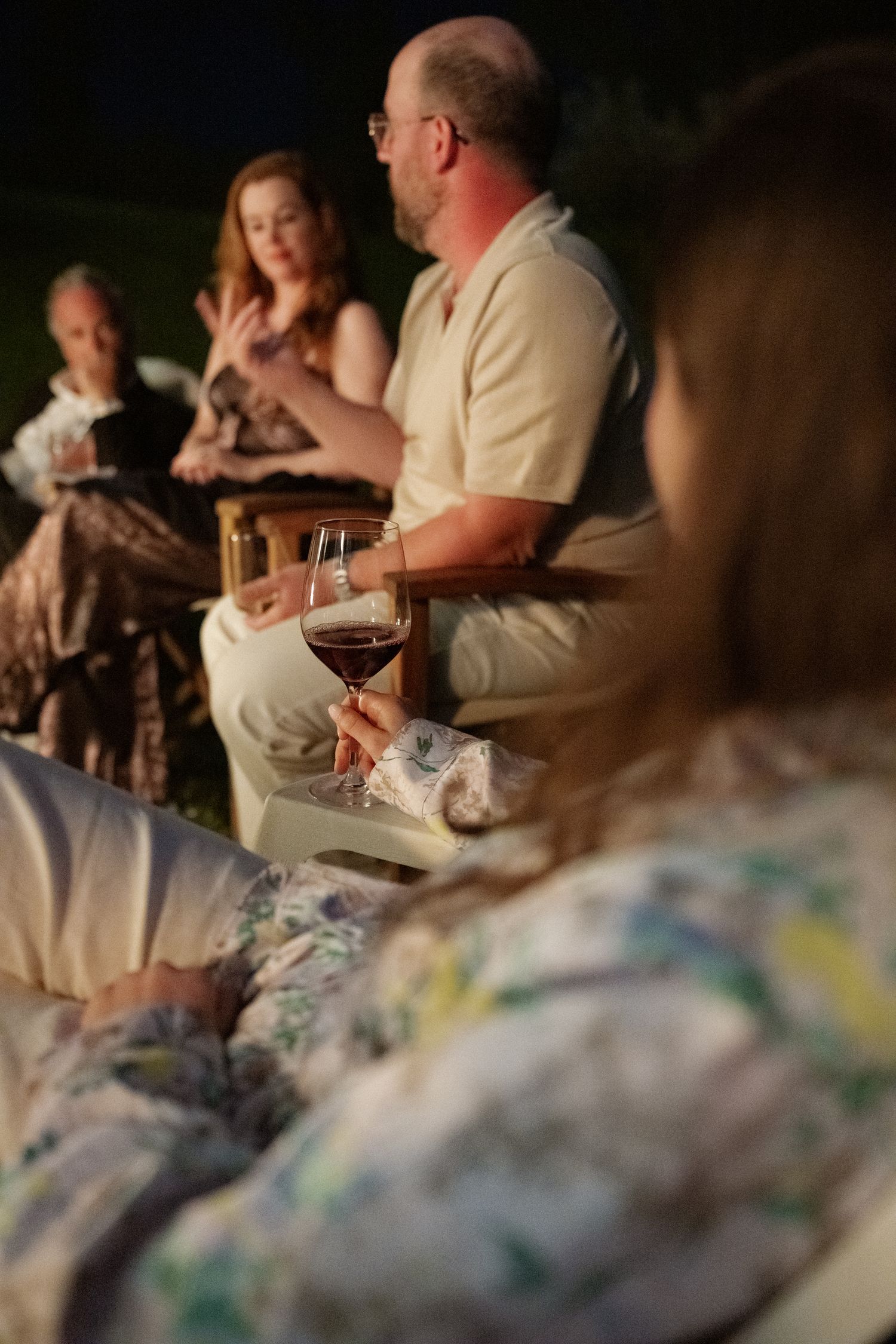 A group of people sitting at a table enjoying drinks and conversation.