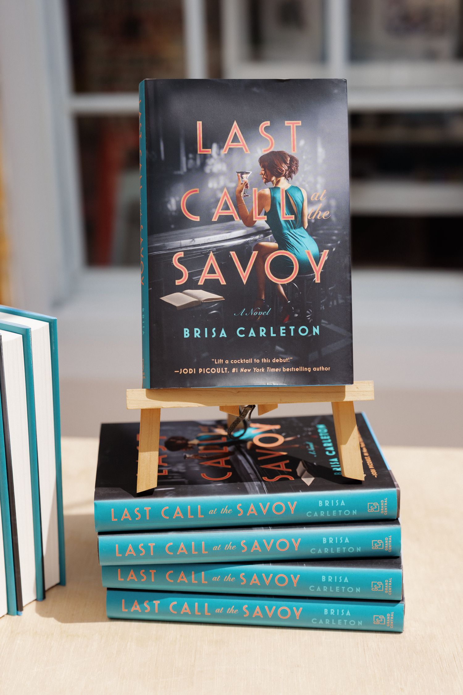 A stack of books titled 'Last Call at the Savoy' by Brisa Carleton.