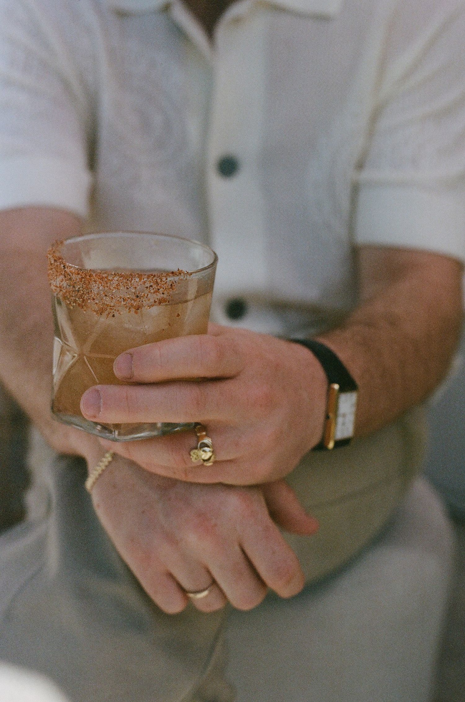 Hands holding cocktail glasses with sugar-rimmed edges.