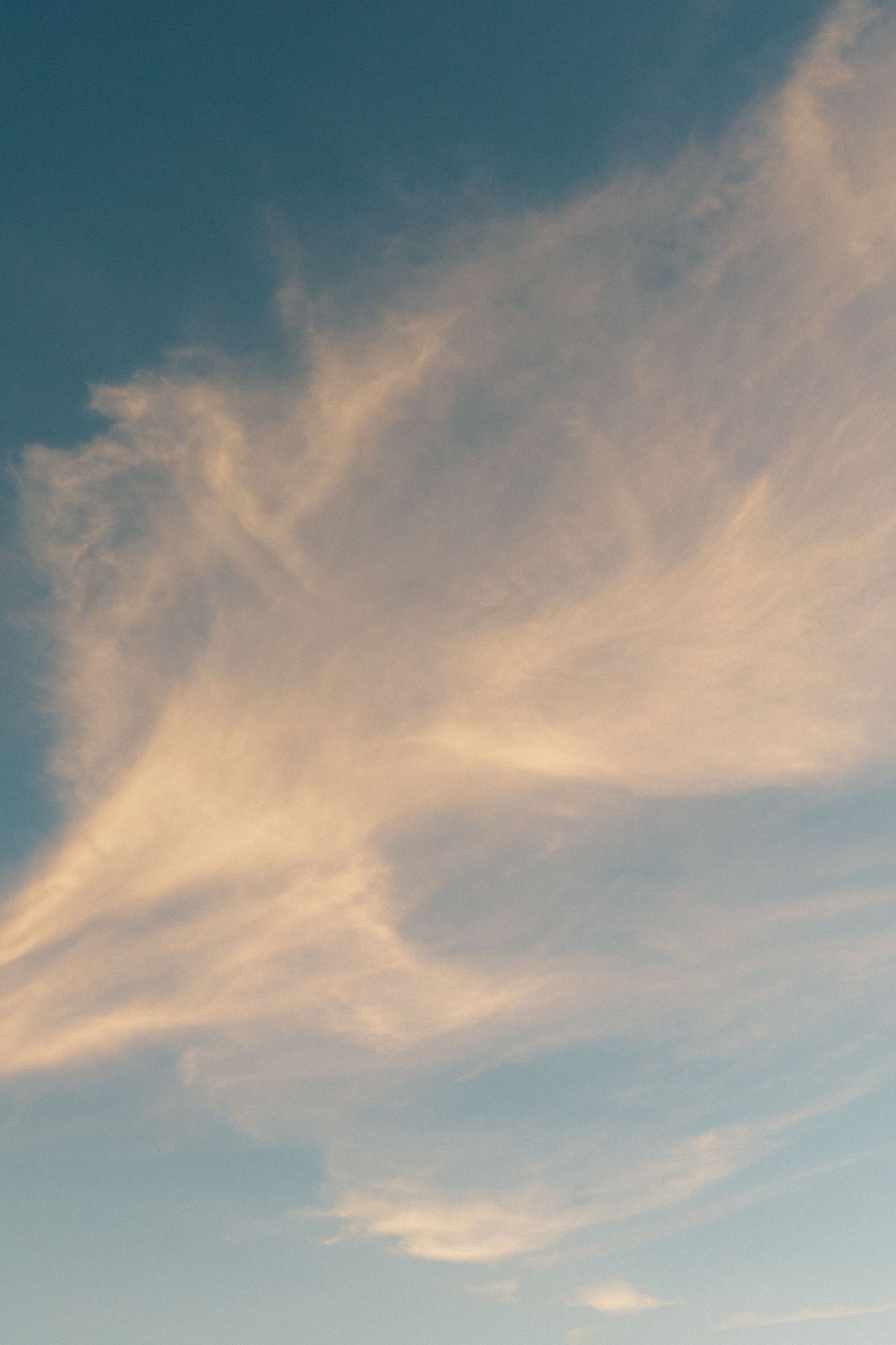 Wispy clouds against a bright blue sky creating a dramatic sunset backdrop.