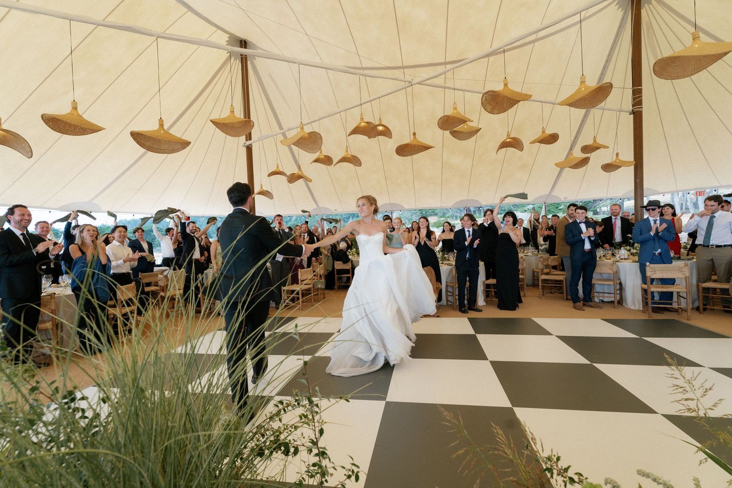 Large white wedding tent with elegant table settings and draped fabric ceiling.