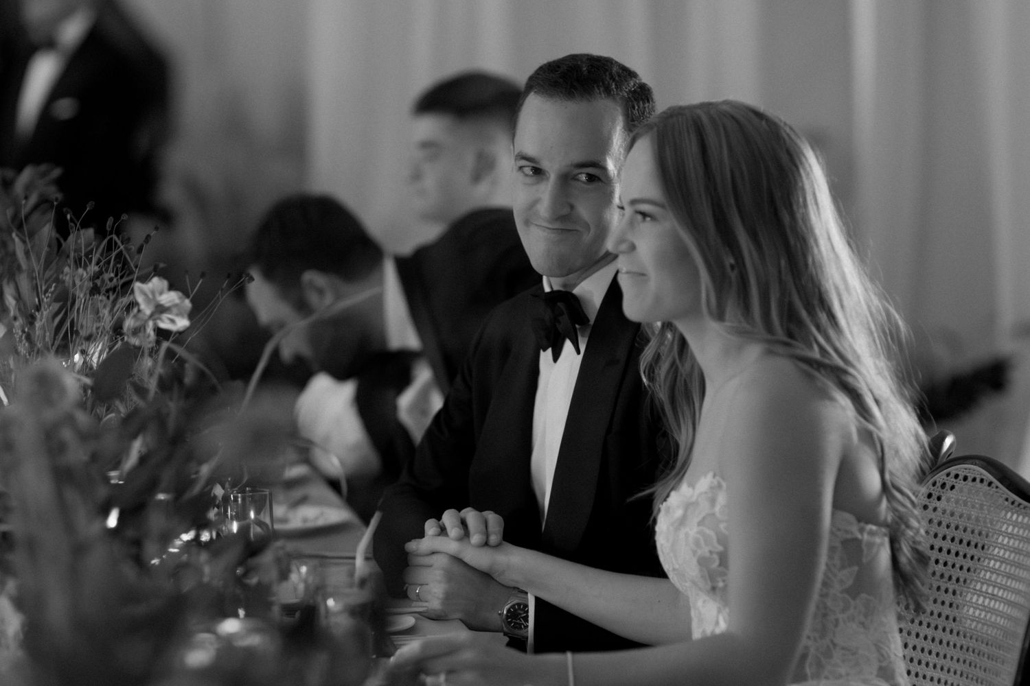 Wedding reception guests enjoying drinks and conversation at an elegant indoor venue.