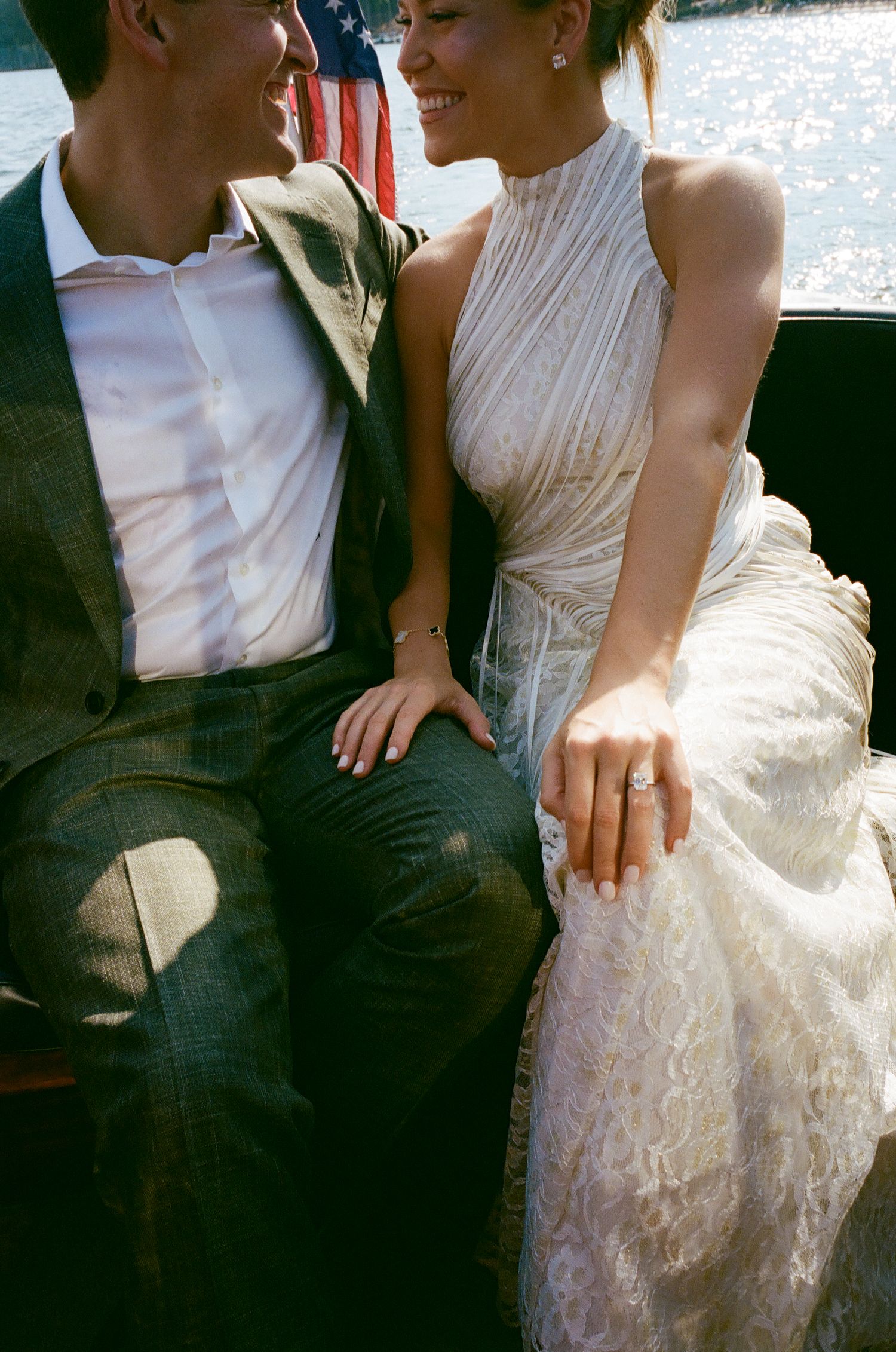 Newlyweds sharing intimate moments while sitting together by the water.