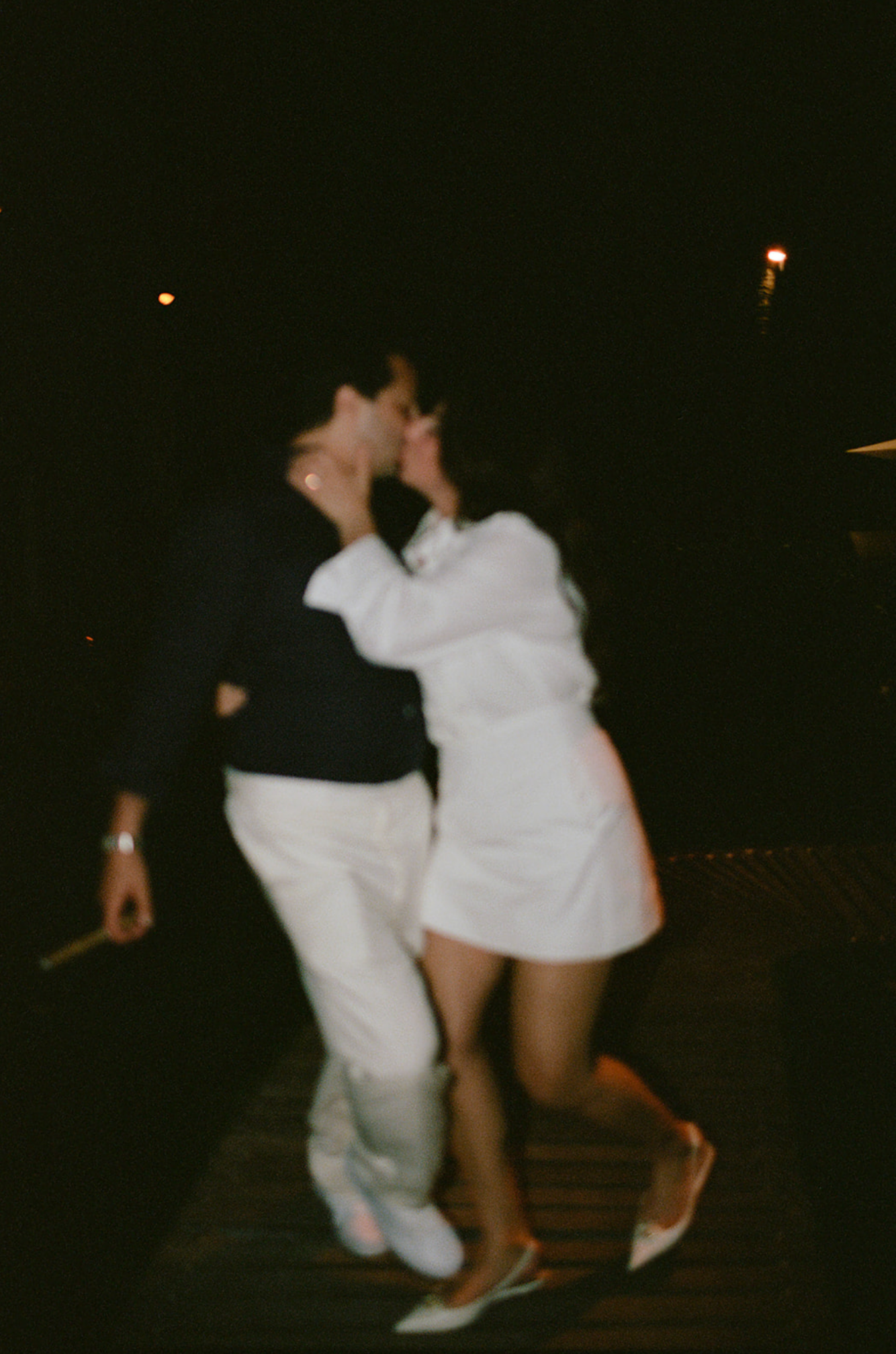 Candid nighttime dance moment captured in vintage film style.