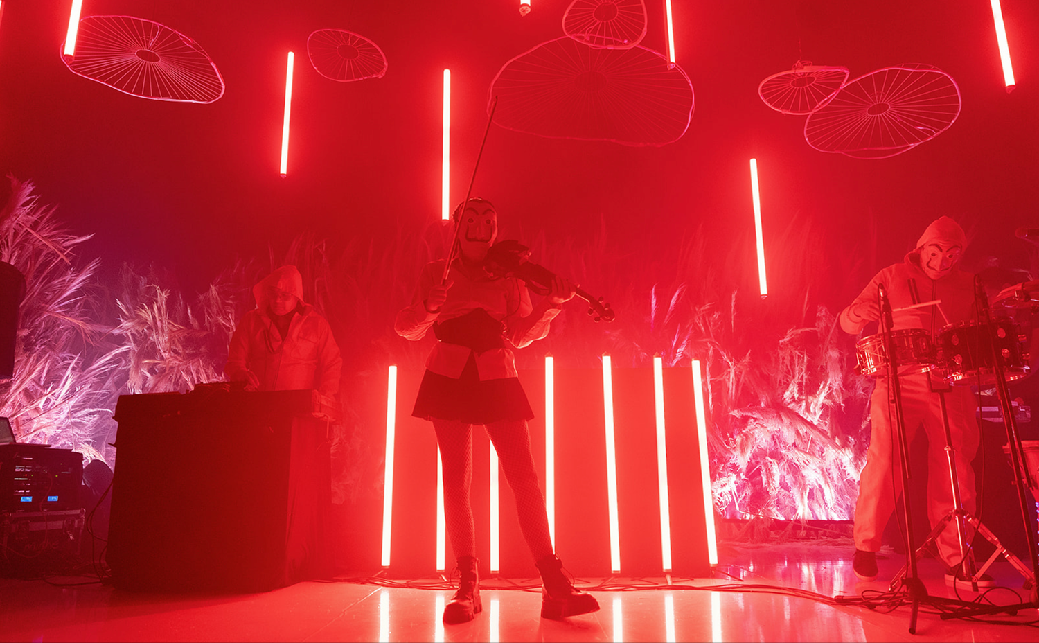 Modern nightclub interior with dramatic red lighting and vertical LED light installations.