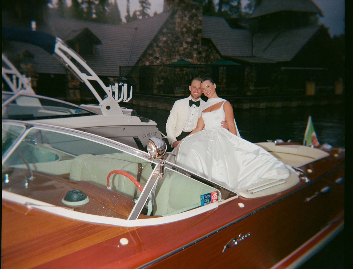 Newlyweds sharing intimate moment on vintage wooden boat.