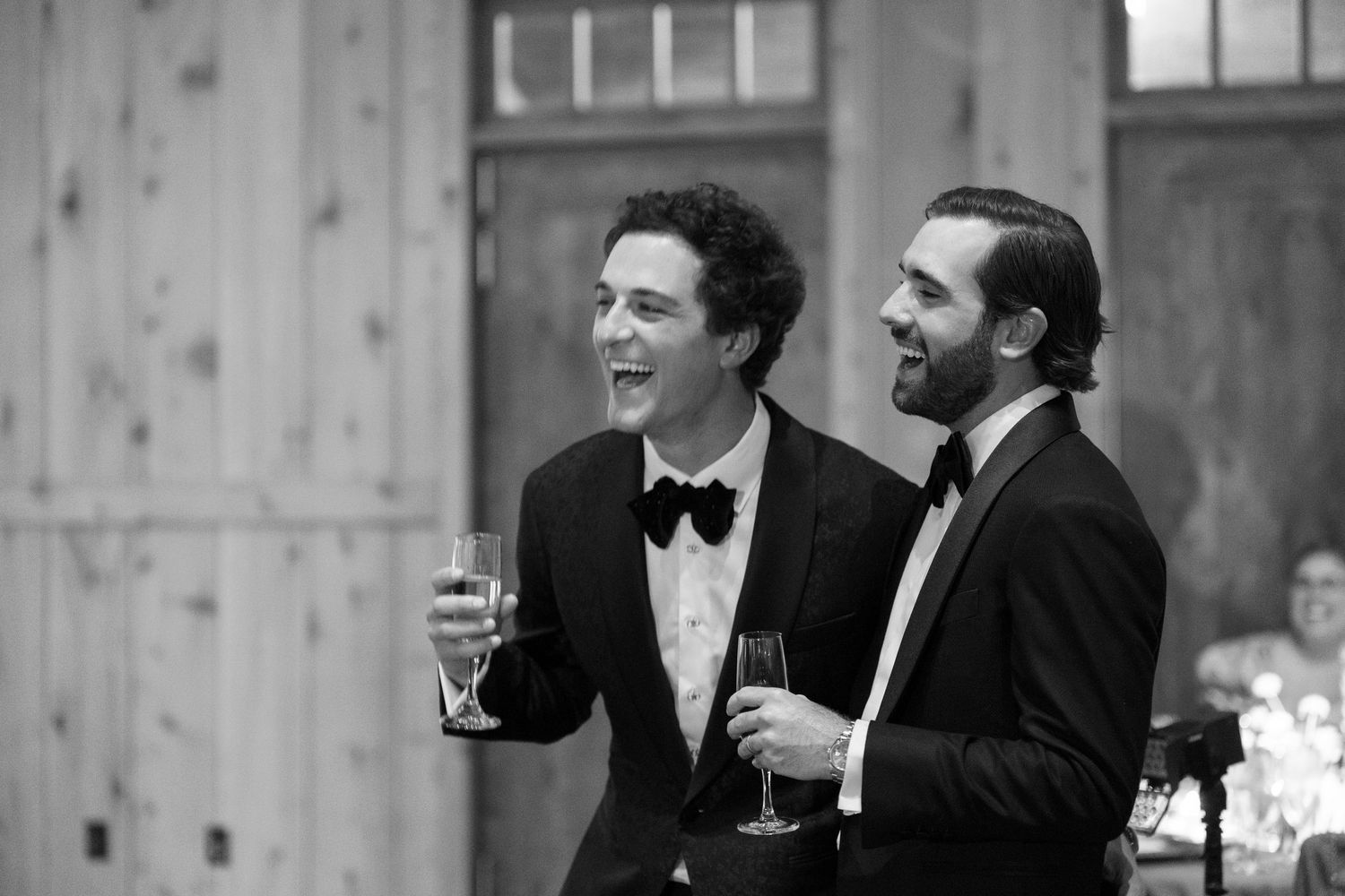 A group of people in formal attire having drinks and conversation at an elegant indoor gathering.