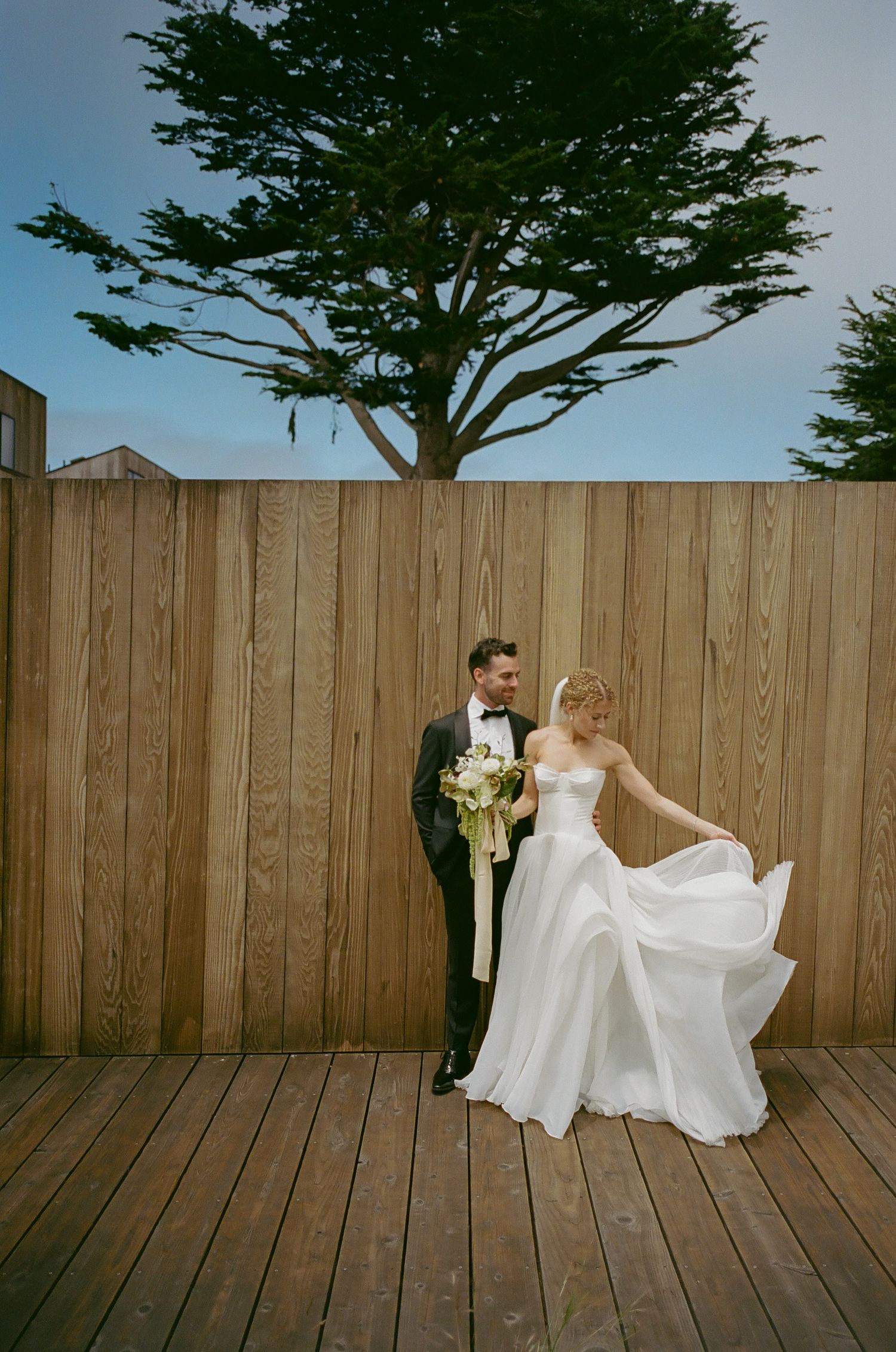 Wedding photography sequence against a wooden fence with flowing white dress.