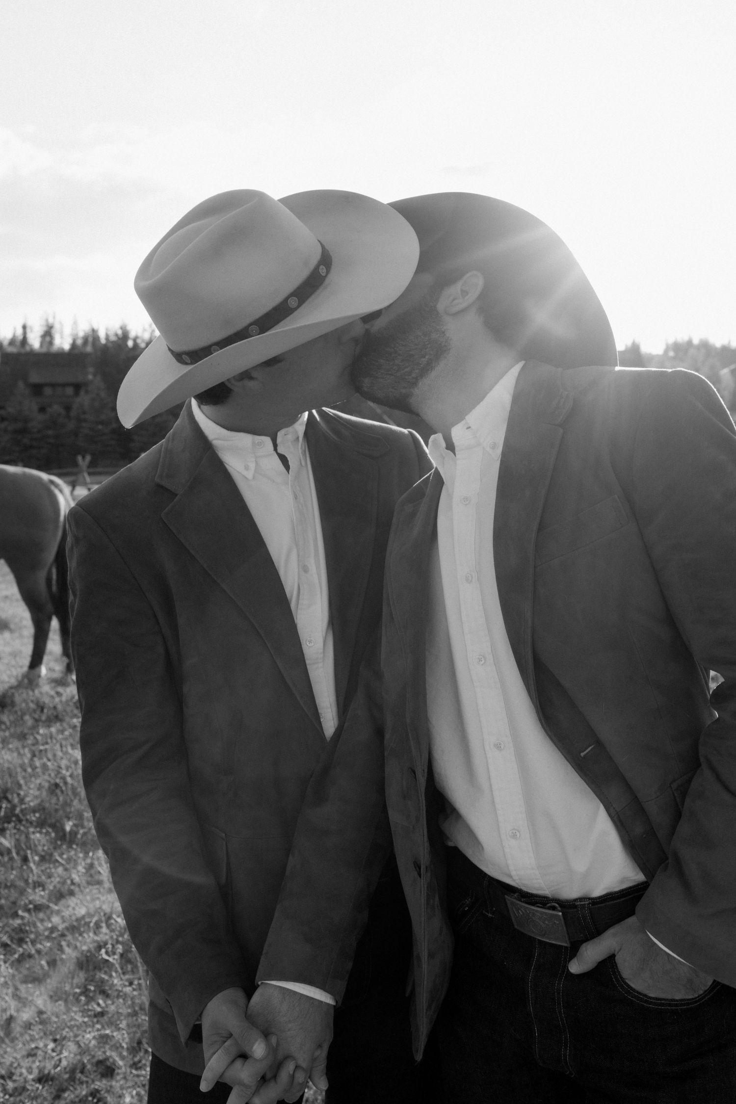 Group wearing cowboy hats and formal attire photographed in black and white.