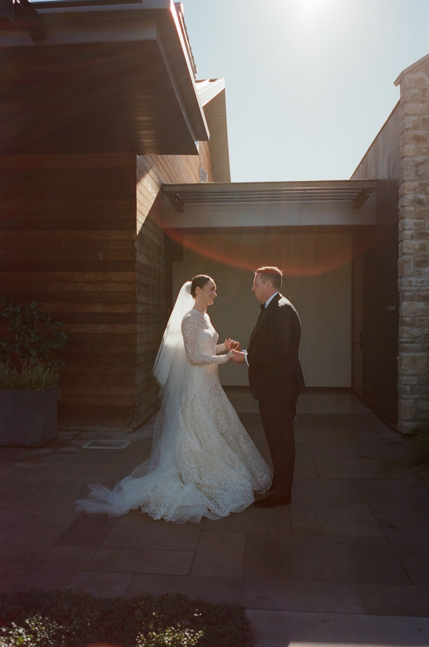 A couple shares an intimate moment during their outdoor wedding ceremony at sunset.