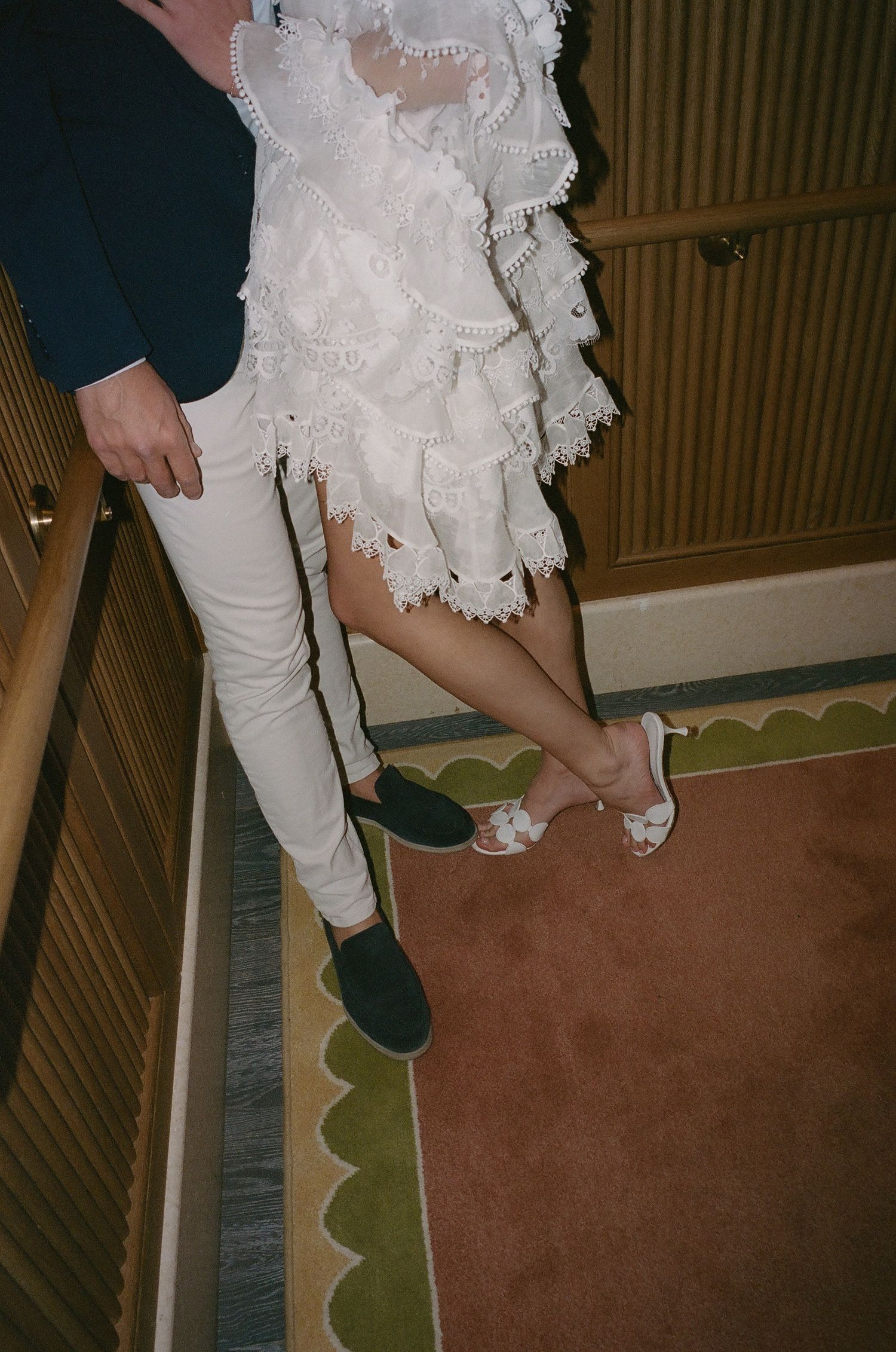 Close-up of dancing feet on a carpeted floor with wood paneling.