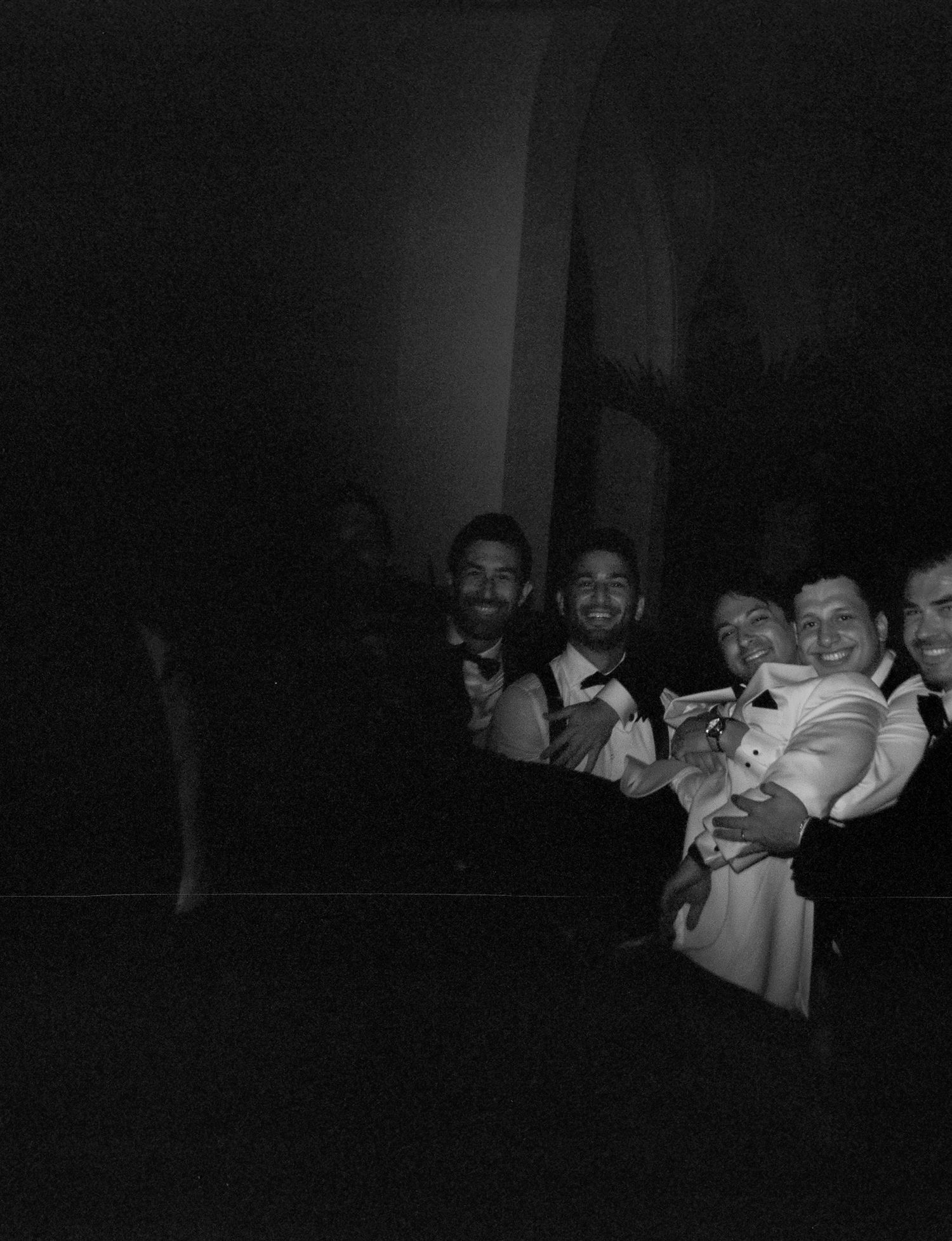 Group enjoying themselves at a dimly lit formal gathering.