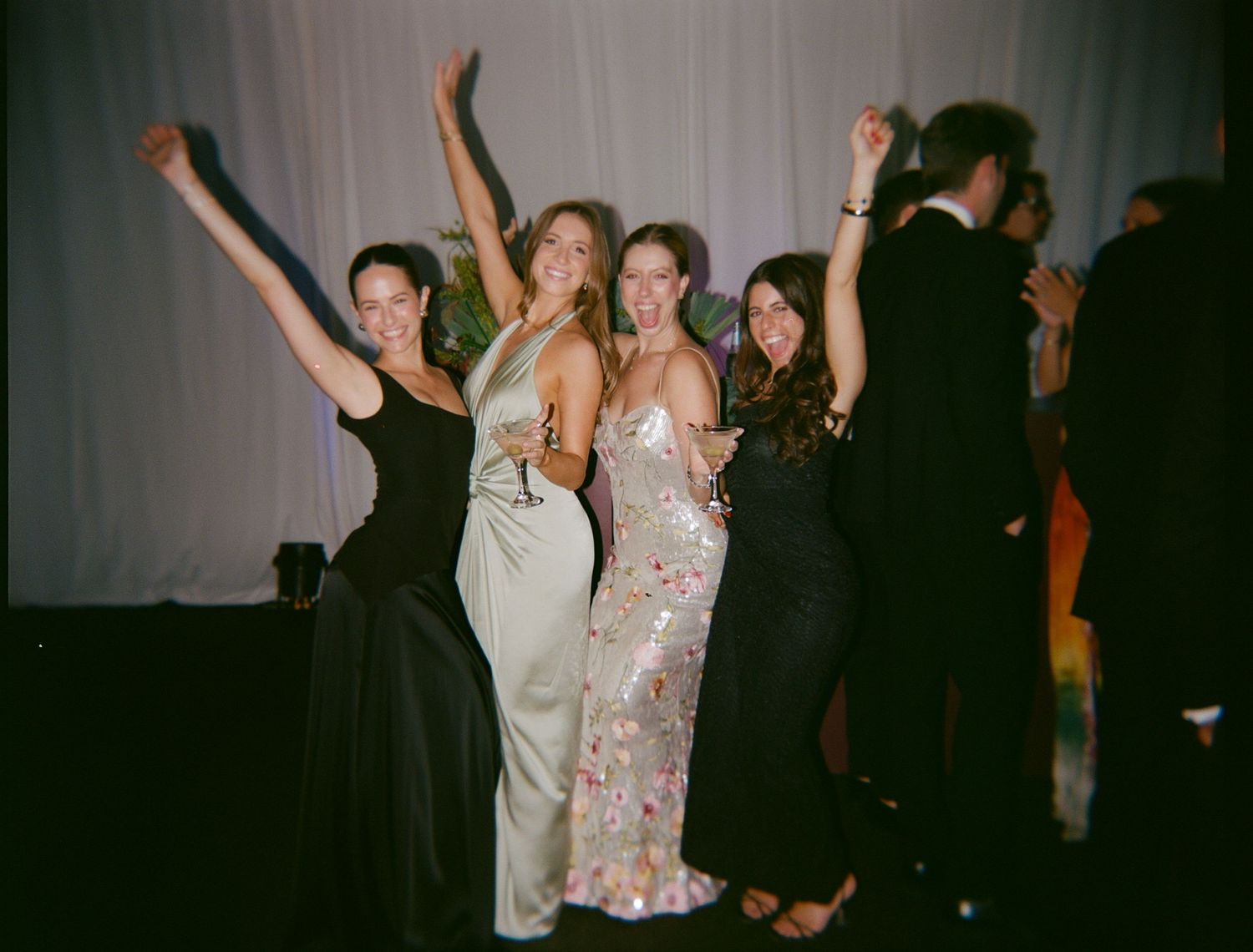 Wedding reception dance party with guests celebrating under white drapes.