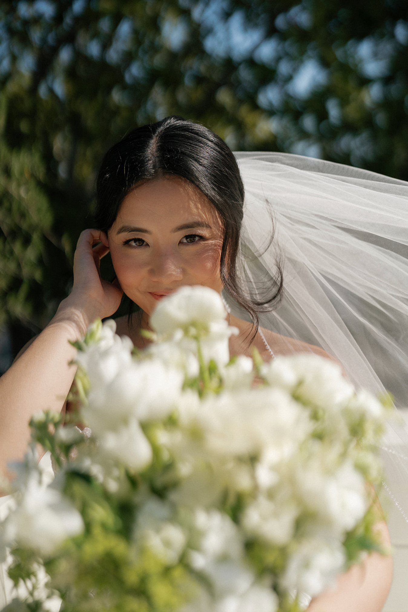 Delicate white wedding veil flowing in the breeze with floral accents.