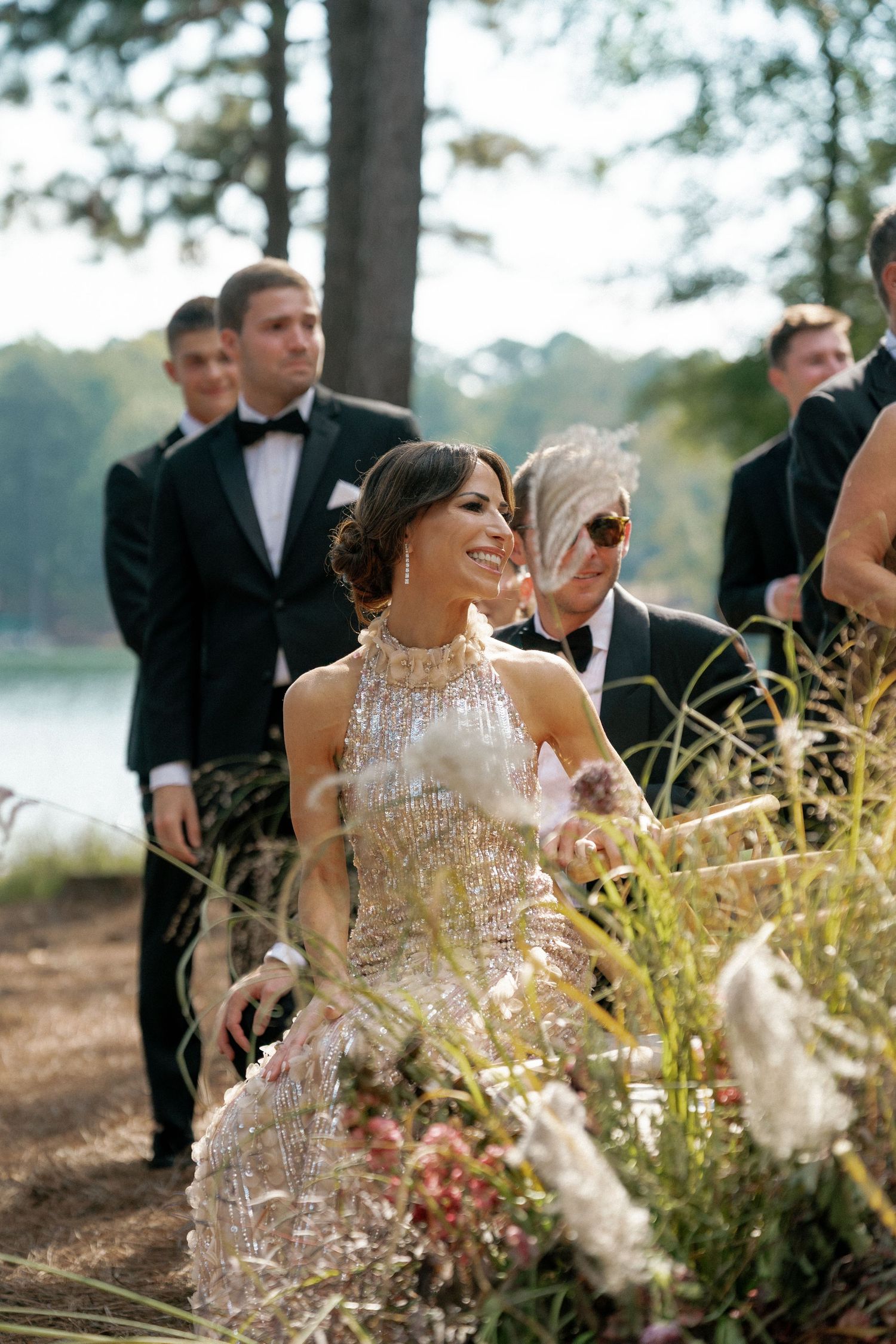 Wedding celebration with sparkling dress and natural wildflower decorations in a forest setting.