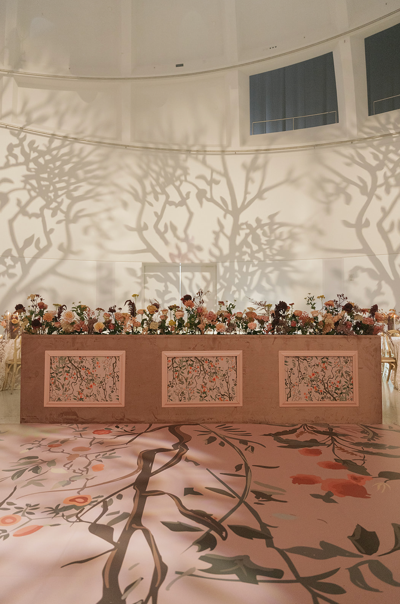 Artistic floral wall installation with shadow patterns in a modern interior space.