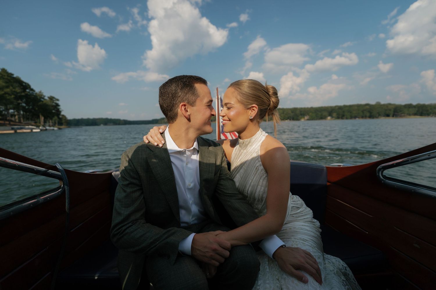 Romantic boat ride on a wooden vessel across a serene lake under blue skies.