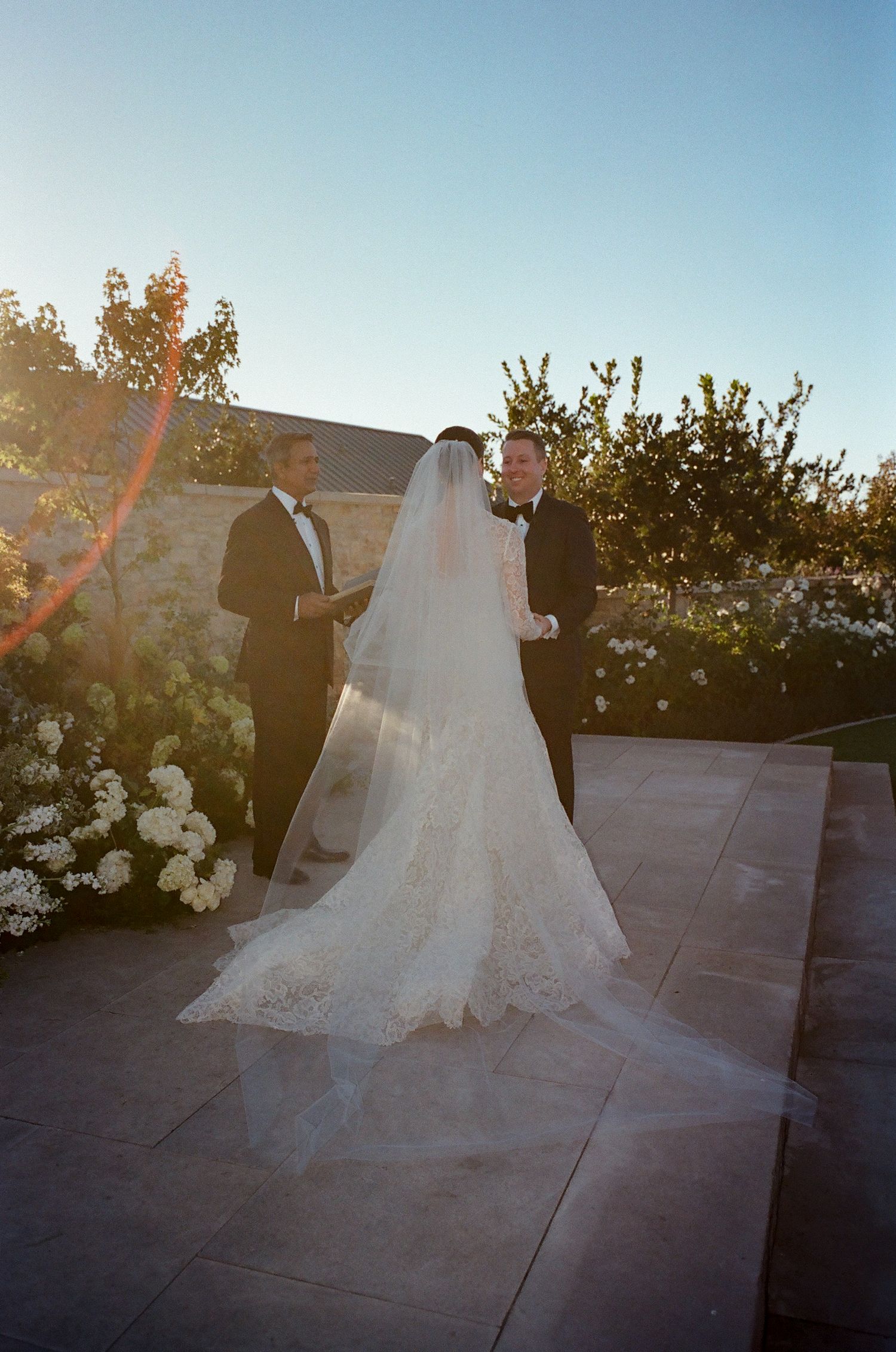 Couple dances together on an outdoor patio during their wedding reception at sunset.
