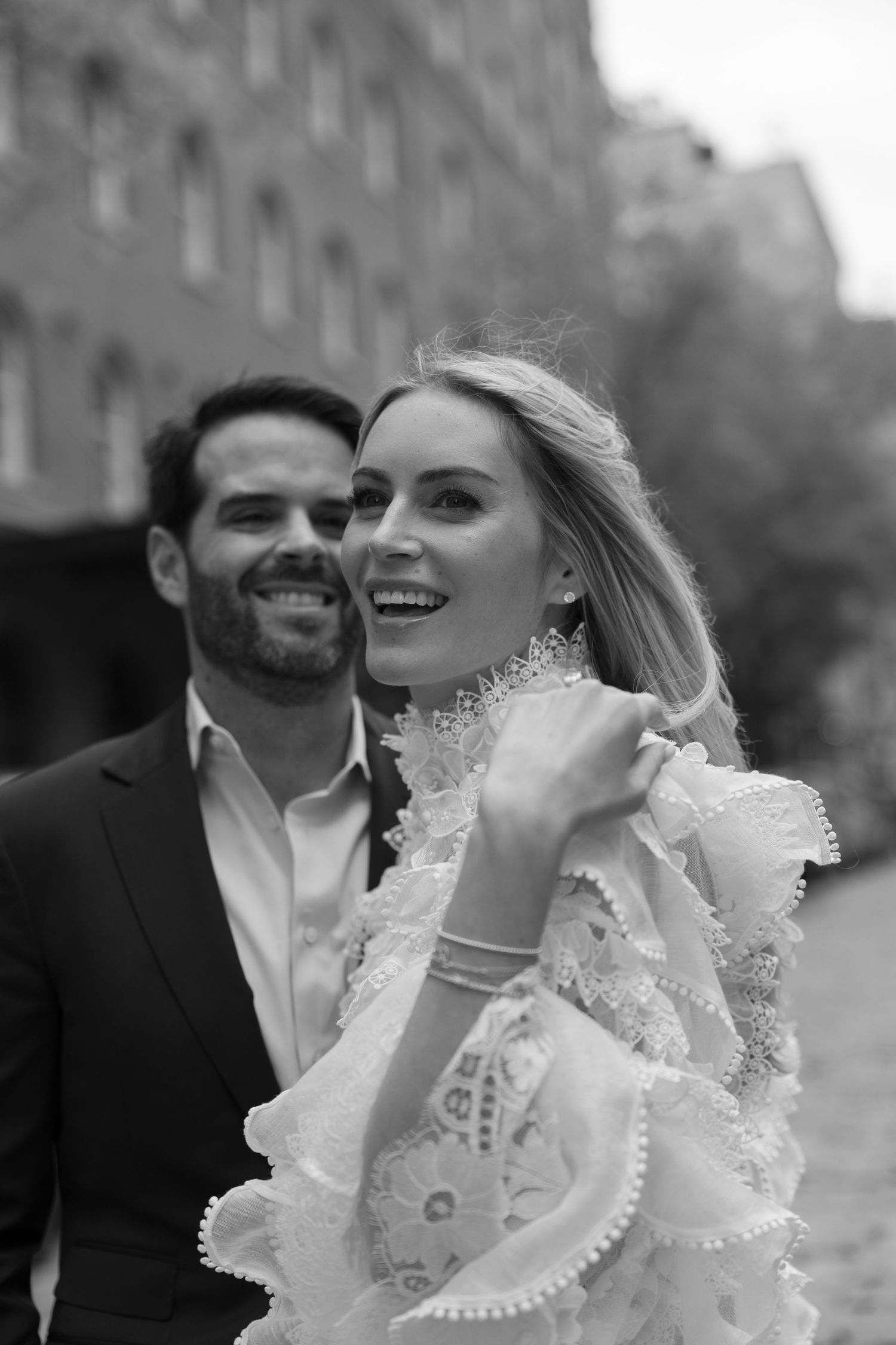 Black and white candid wedding portrait showing joyful laughter and emotion.