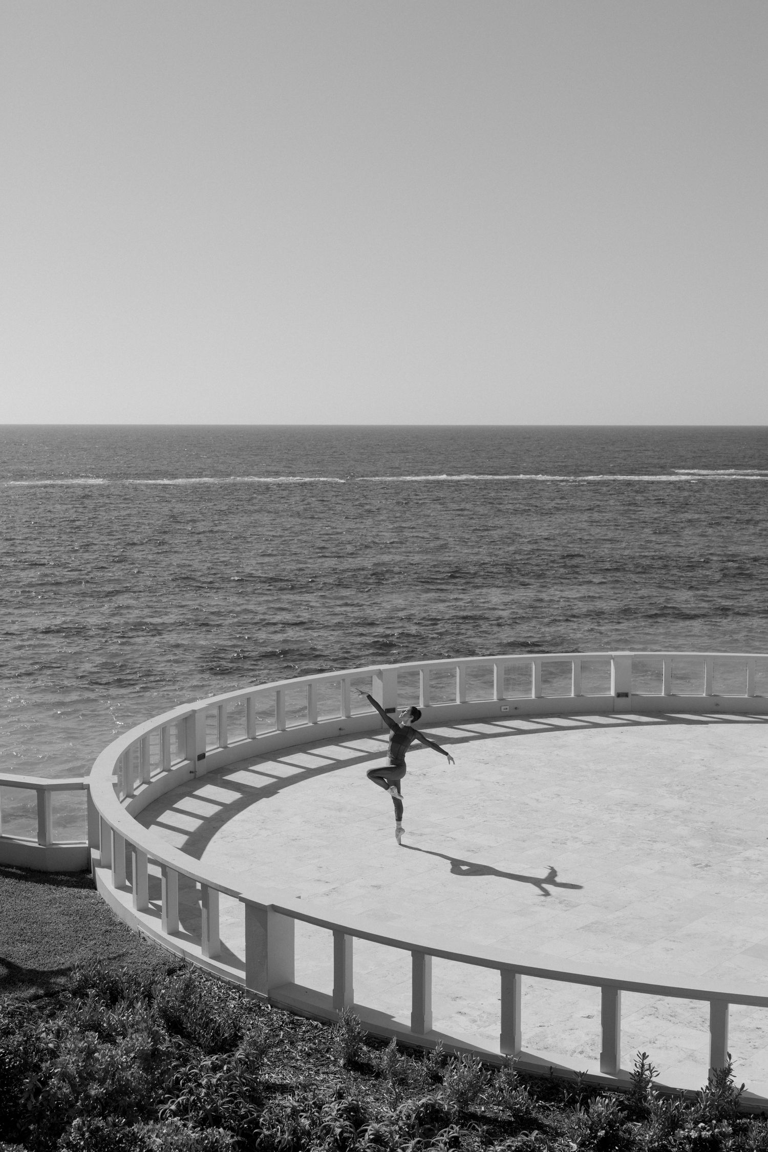 A black and white image of a circular platform overlooking the ocean.